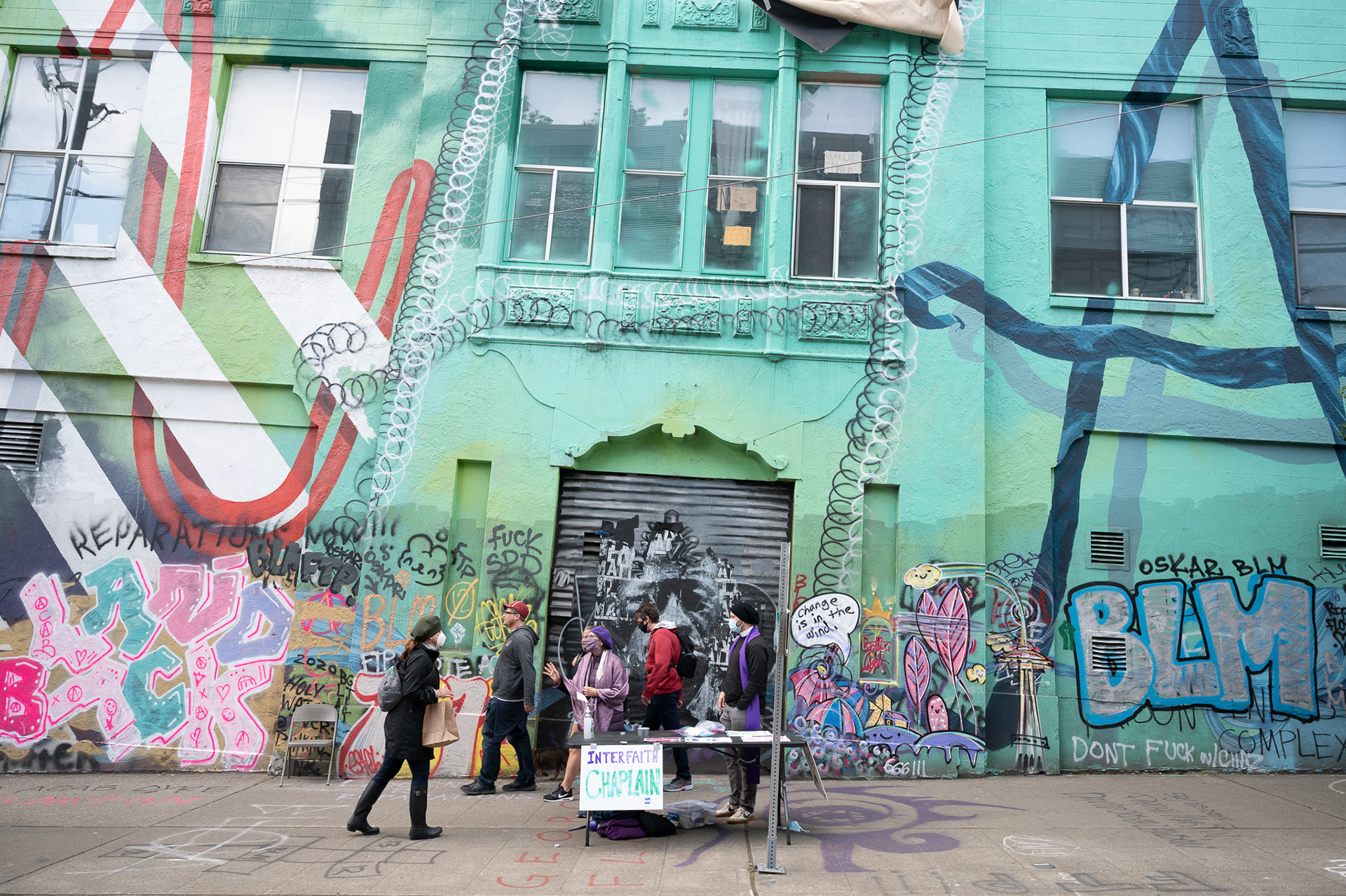 Chaplains Chava Monastersky (Jewish) and Aaron Monts (Christian) speak with a visitor to the Capitol Hill Occupied Protest (CHOP) in Seattle at the ‘Interfaith Chaplain’ station located near the center of the six-block enclave on Saturday, June 13.