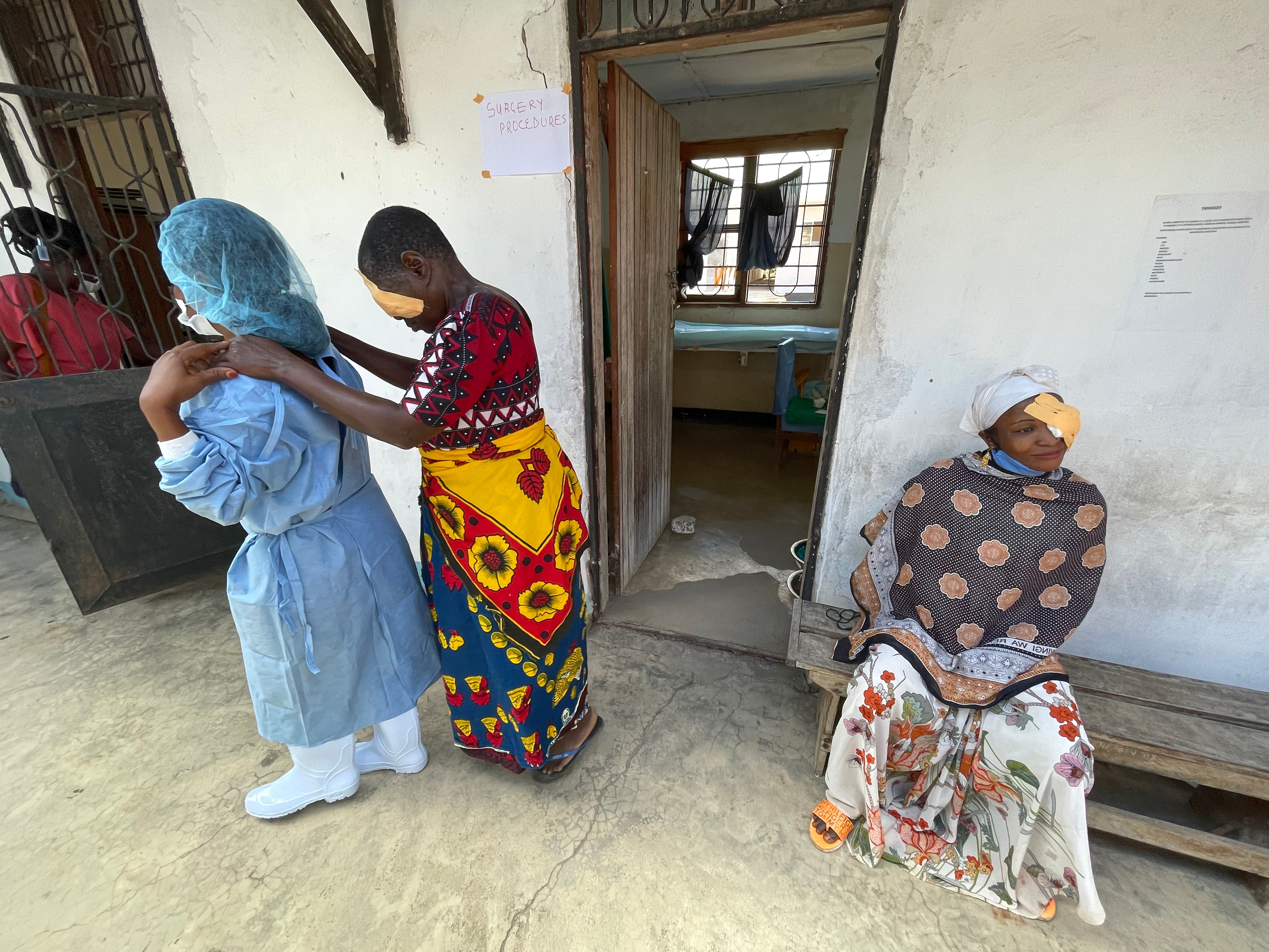 A nurse leads a patient from the surgery room as Dalin Bakari Ngalanga waits following trachoma surgery at the Mkuranga District Hospital near Dar Es Salaam, Tanzania.