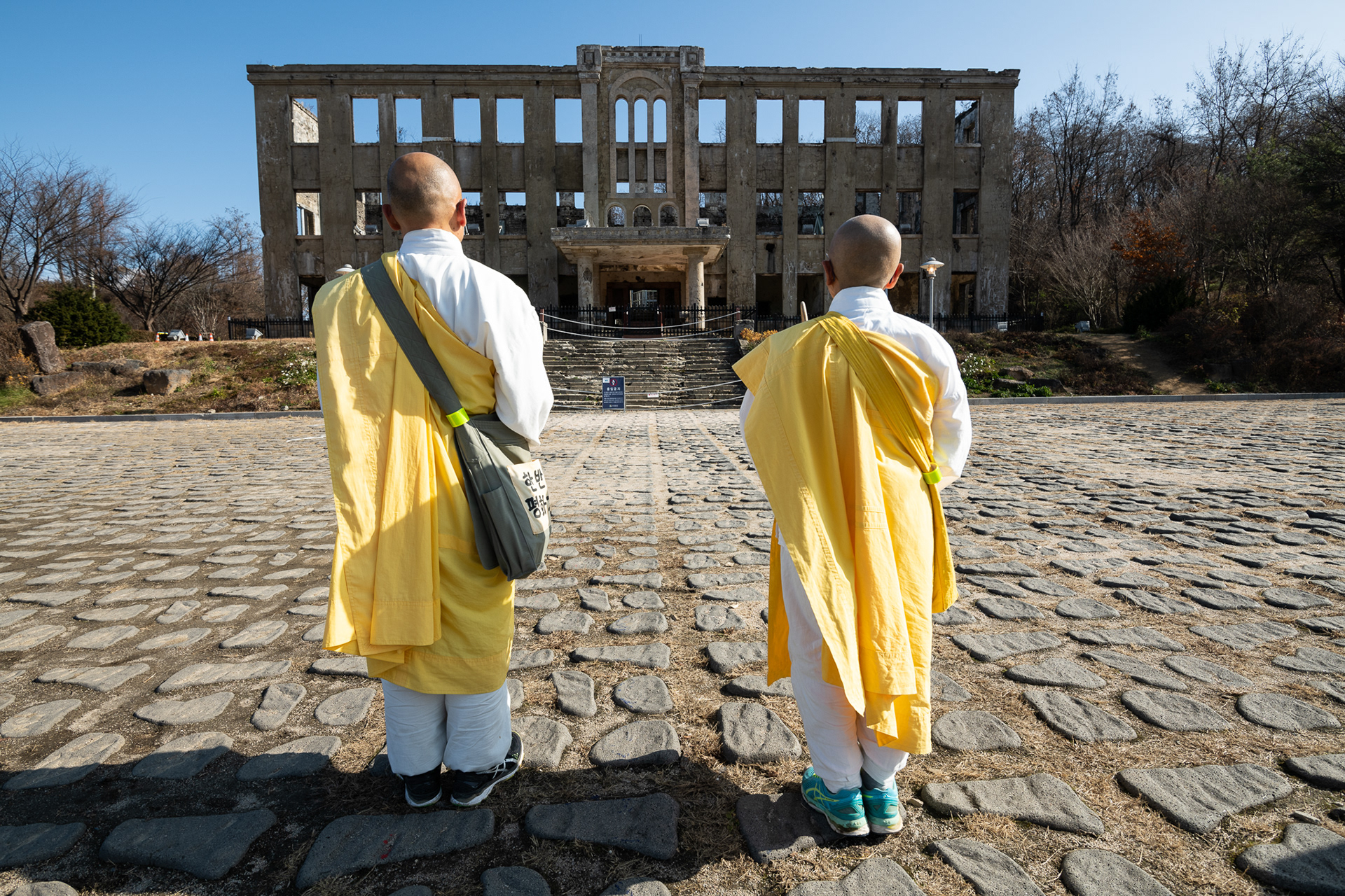 Japanese Buddhist monks chant in front of the bombed out North Korean Labor Party HQ in Cheorwon, South Korea, just south of the Civilian Control Zone and DMZ. Prior to the ceasefire, this land was part of North Korea. These monks have prayed at this site every day for nearly a decade. 