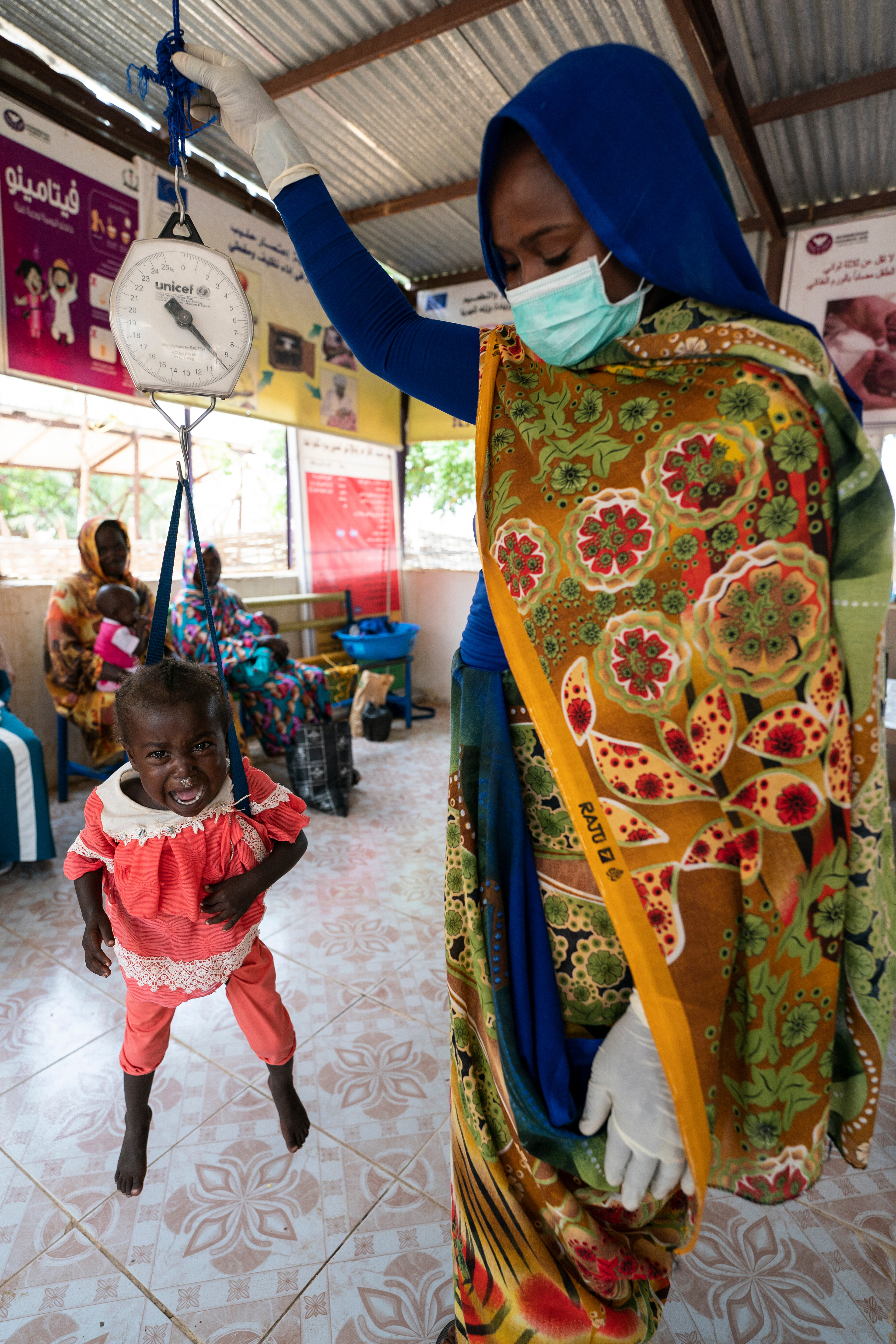 A child is weighed as part of a malnourishment mitigation program at the Norwegian Church Aid sponsored health center in the Beliel IDP Camp in South Darfur, Sudan.
