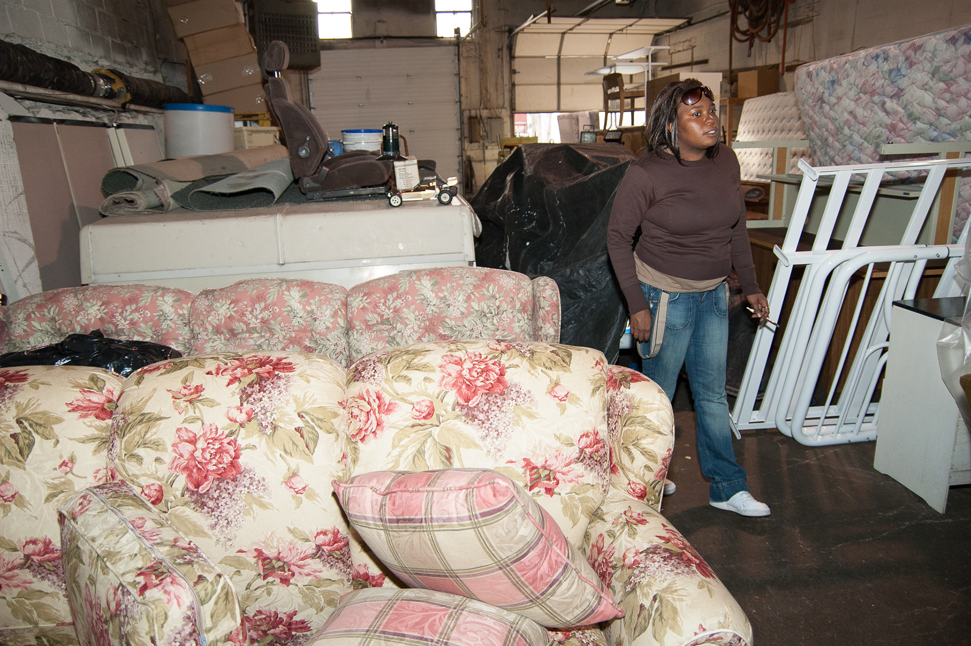 Kim searches through the IHNWC “heaven and hearth” furniture warehouse. She will get a couch, dressers, washer, dryer, chairs and beds for her new apartment.