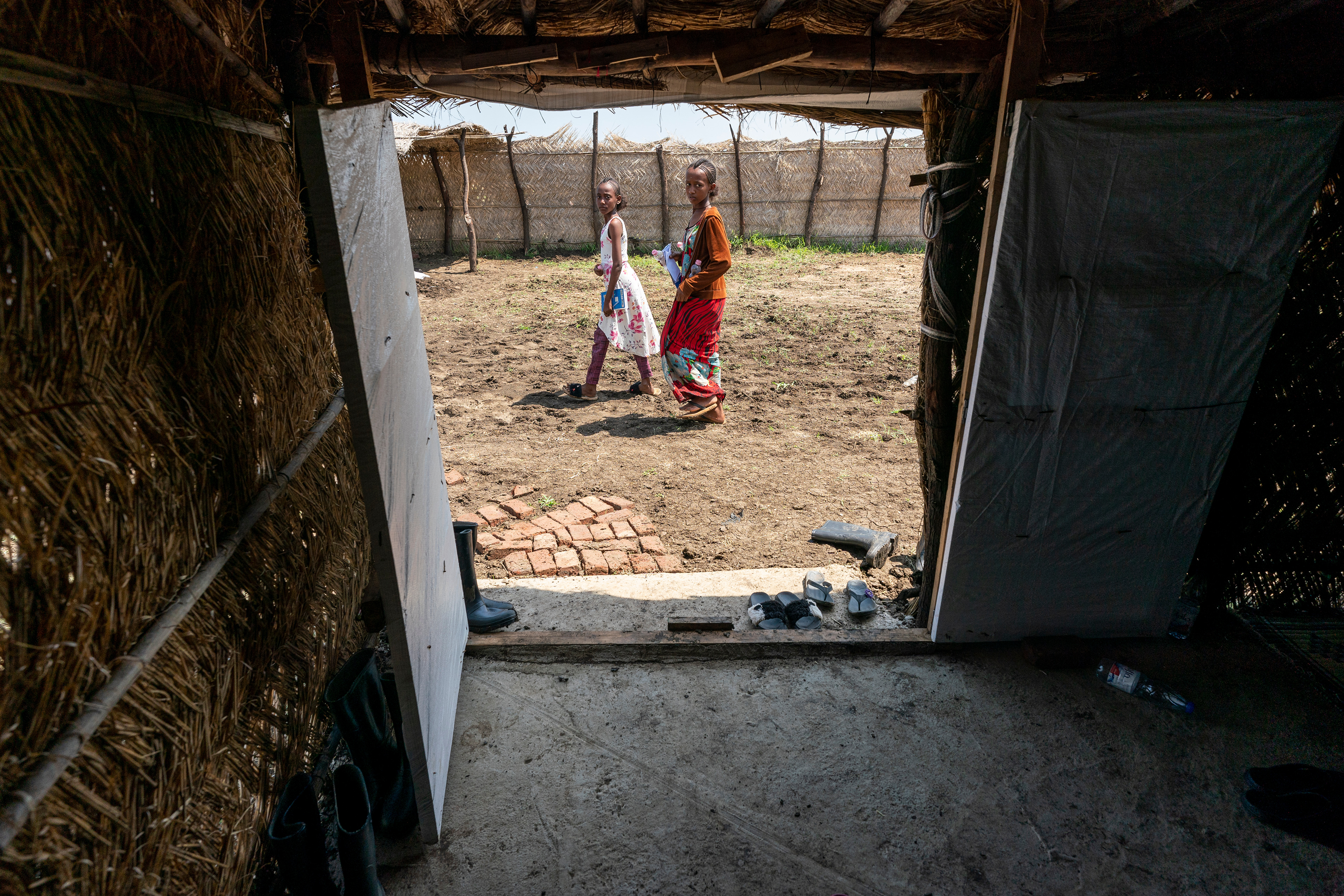 Studnts walks through the safe space compound for  Tigrayan women and girls sponsored by Norwegian Church Aid in the Tuneidba Refugee Camp near Gedaref, Sudan. The camp currently hosts 20,000 people where several groups are working to provide basic services.