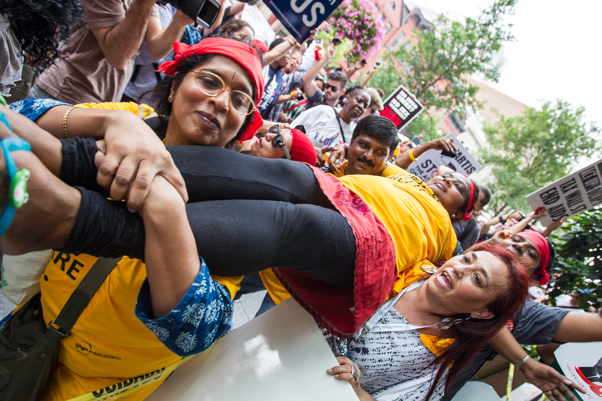 Protest block the street and hoist a person as if dead during the 2012 International AIDS conference calling on pharmaceutical companies to provide access to HIV/AIDS treatment drugs. 