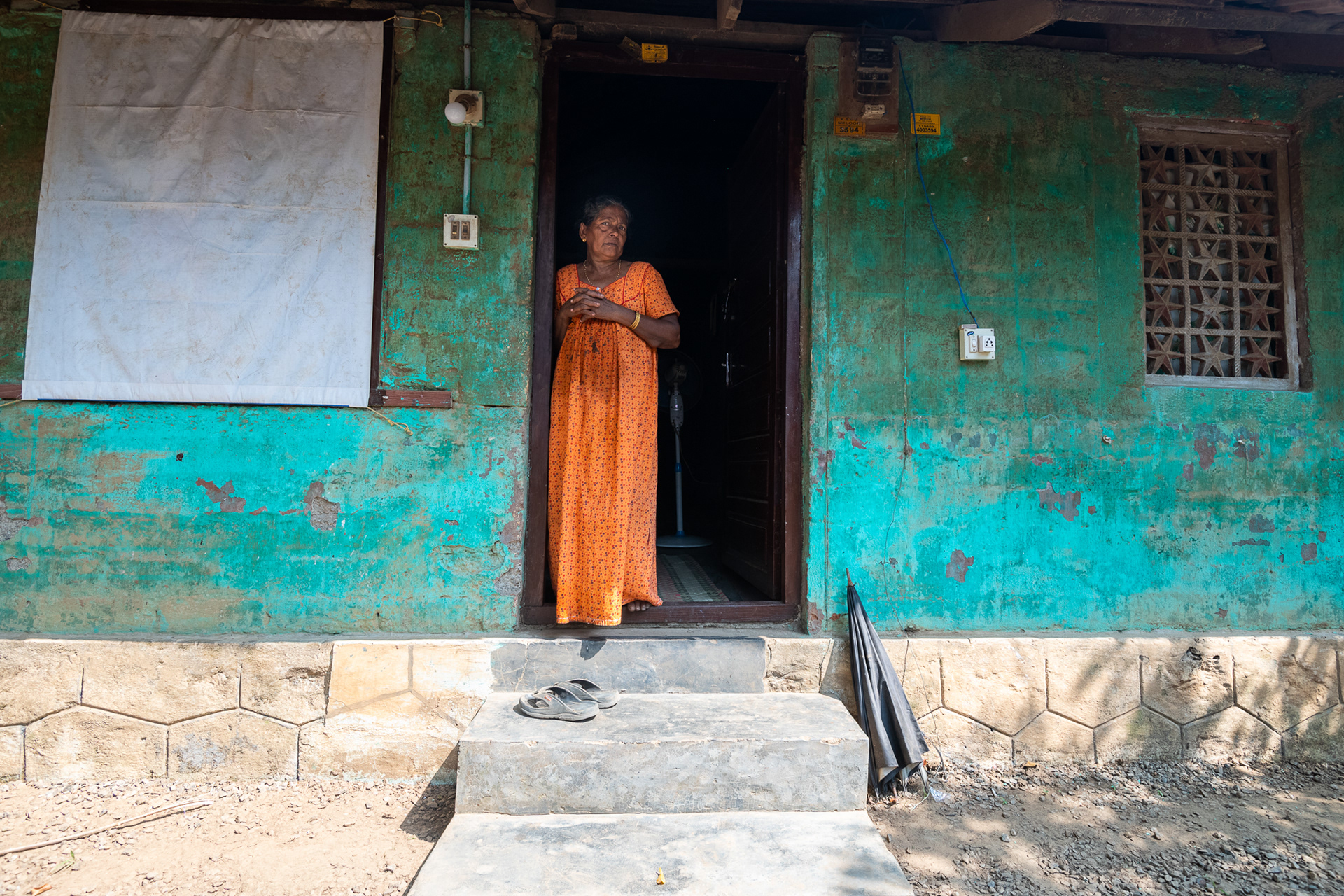 Philomena Pulikilan stands outside her home following a visit by ACT Alliance partner CASA (Church's Auxiliary for Social Action). The organization provided sanitation and hygiene kits, along with household items, to the family following the August 14-18, 2018 flood in Kerala, India that covered her home and destroyed most of the family's belongings.