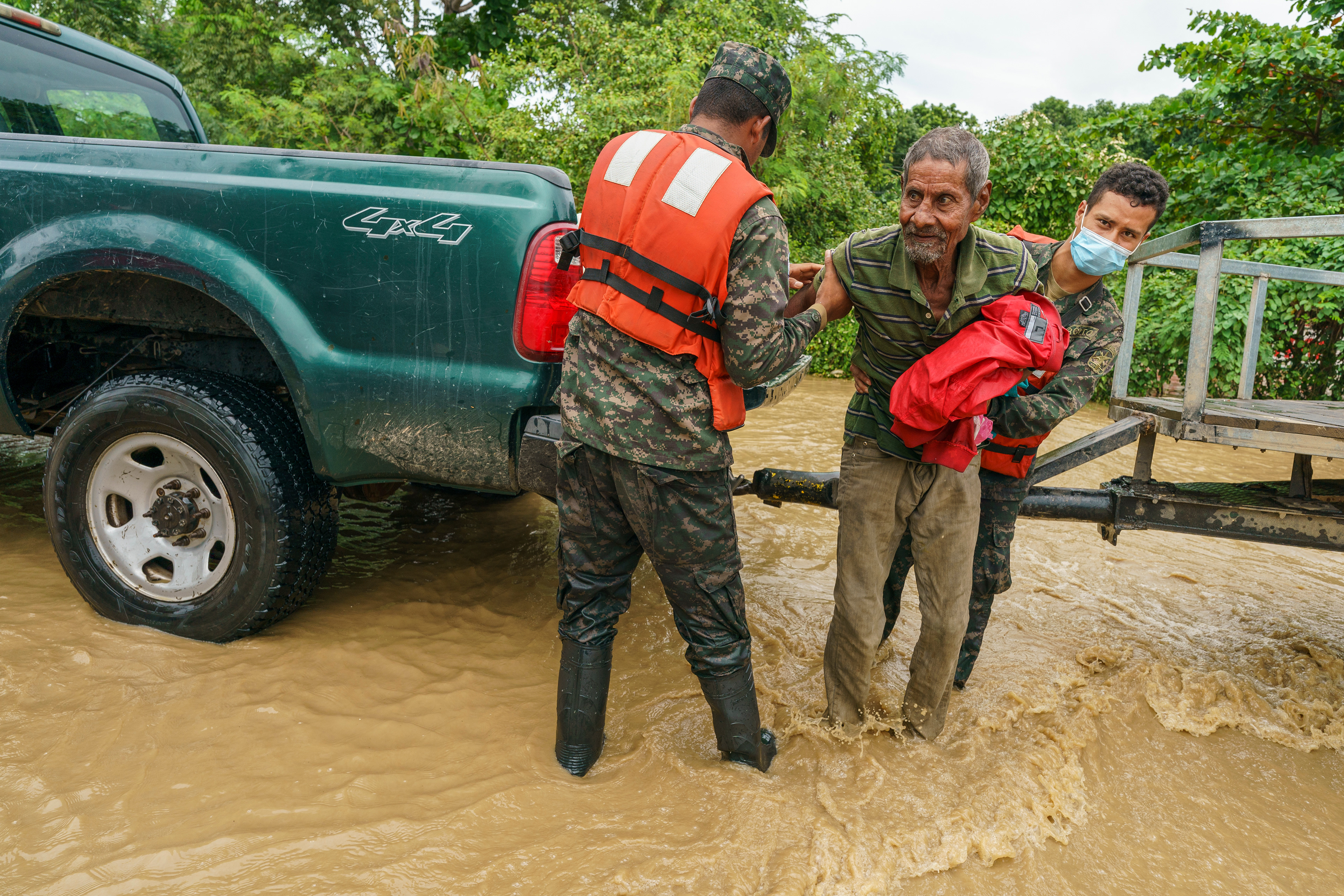 A military police team evacuate an elderly man from his submerged home in Jerusalen, Honduras, during flooding caused by Hurricane Iota in November of 2020.