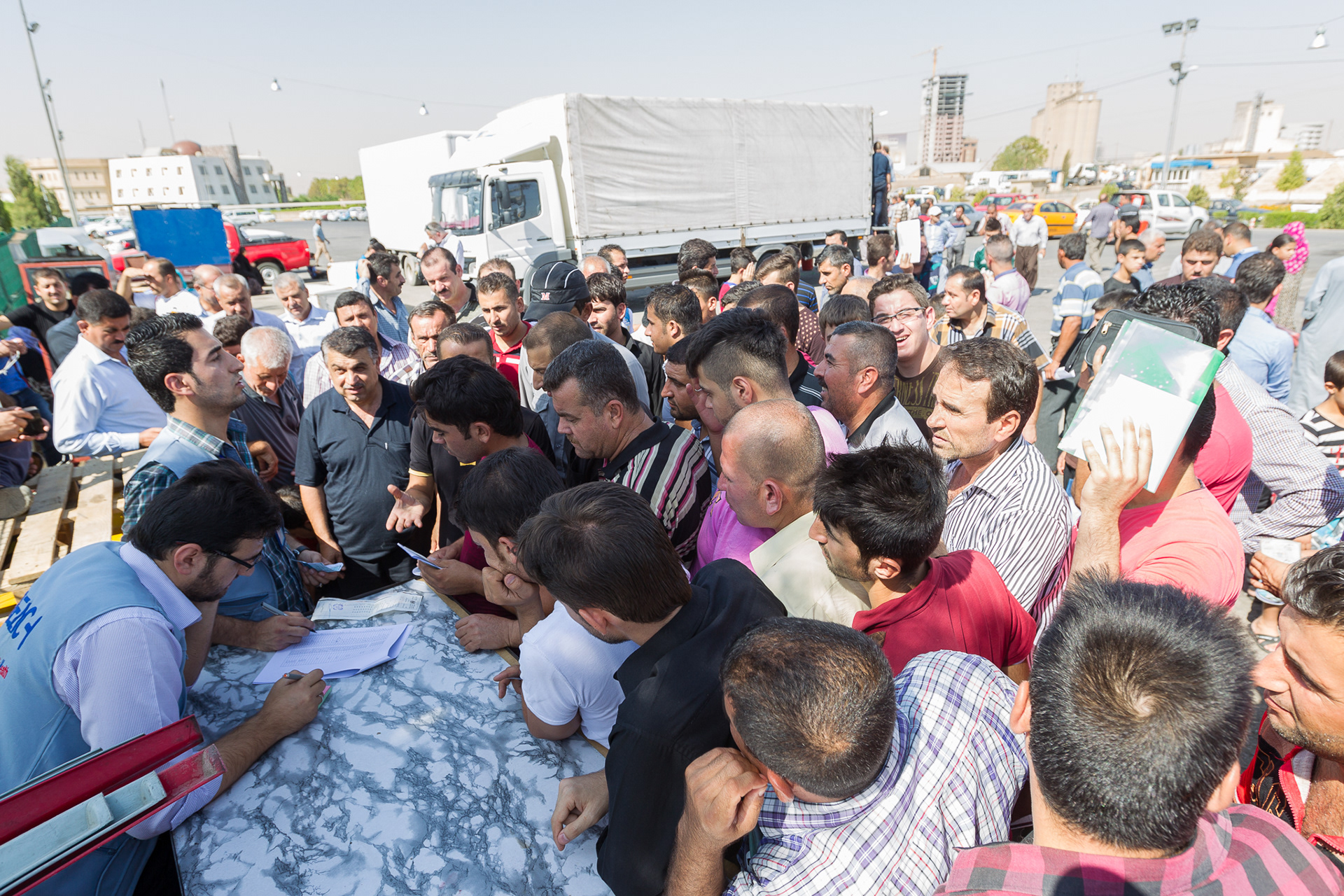 A large crowd gathers as REACH staff verify family information at a food distribution center for internally displaced persons (IDPs) in Erbil, Iraq.
