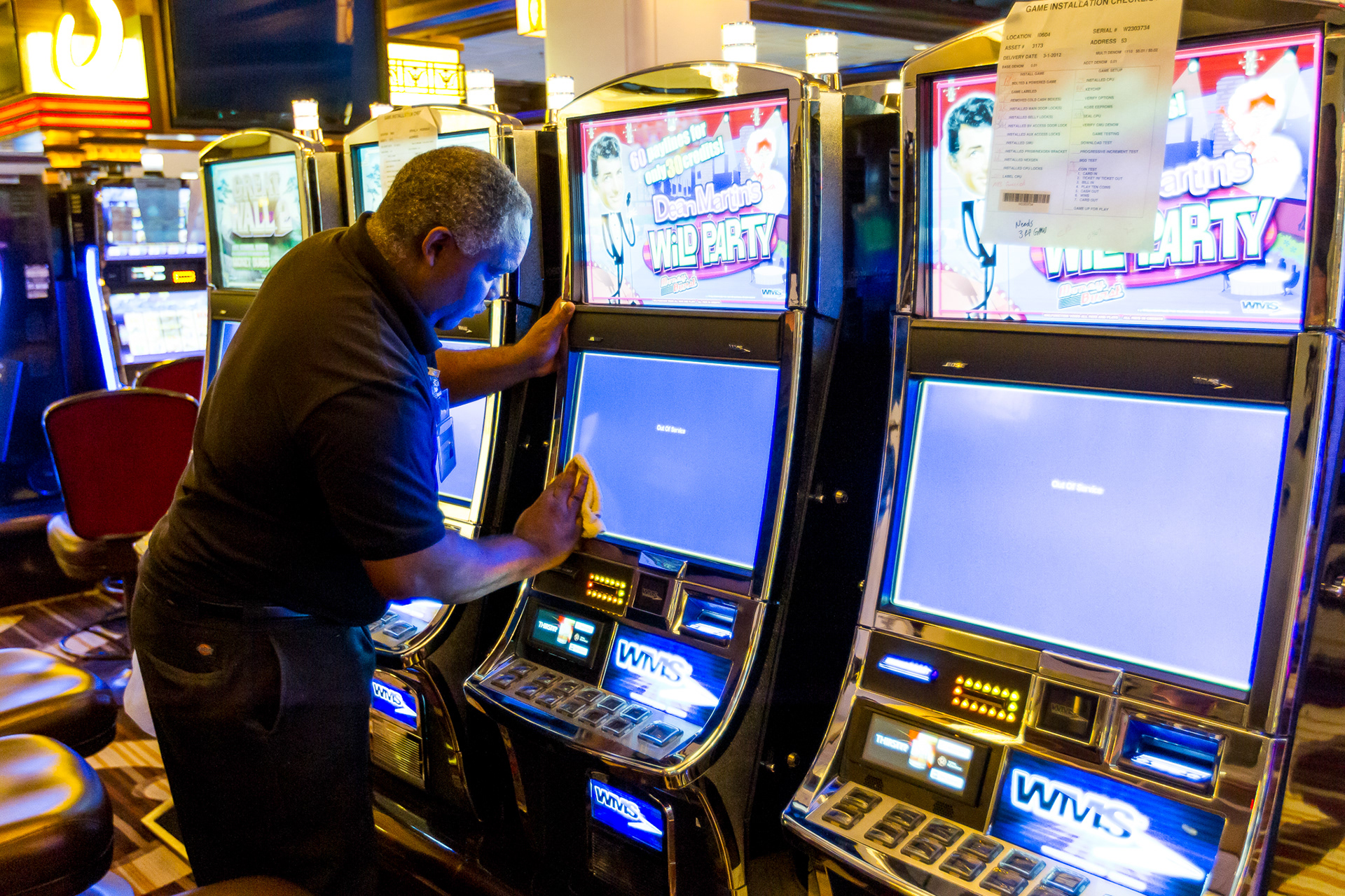 A worker cleans slot machine displays prior to the opening of Cleveland's Horseshoe Casino.