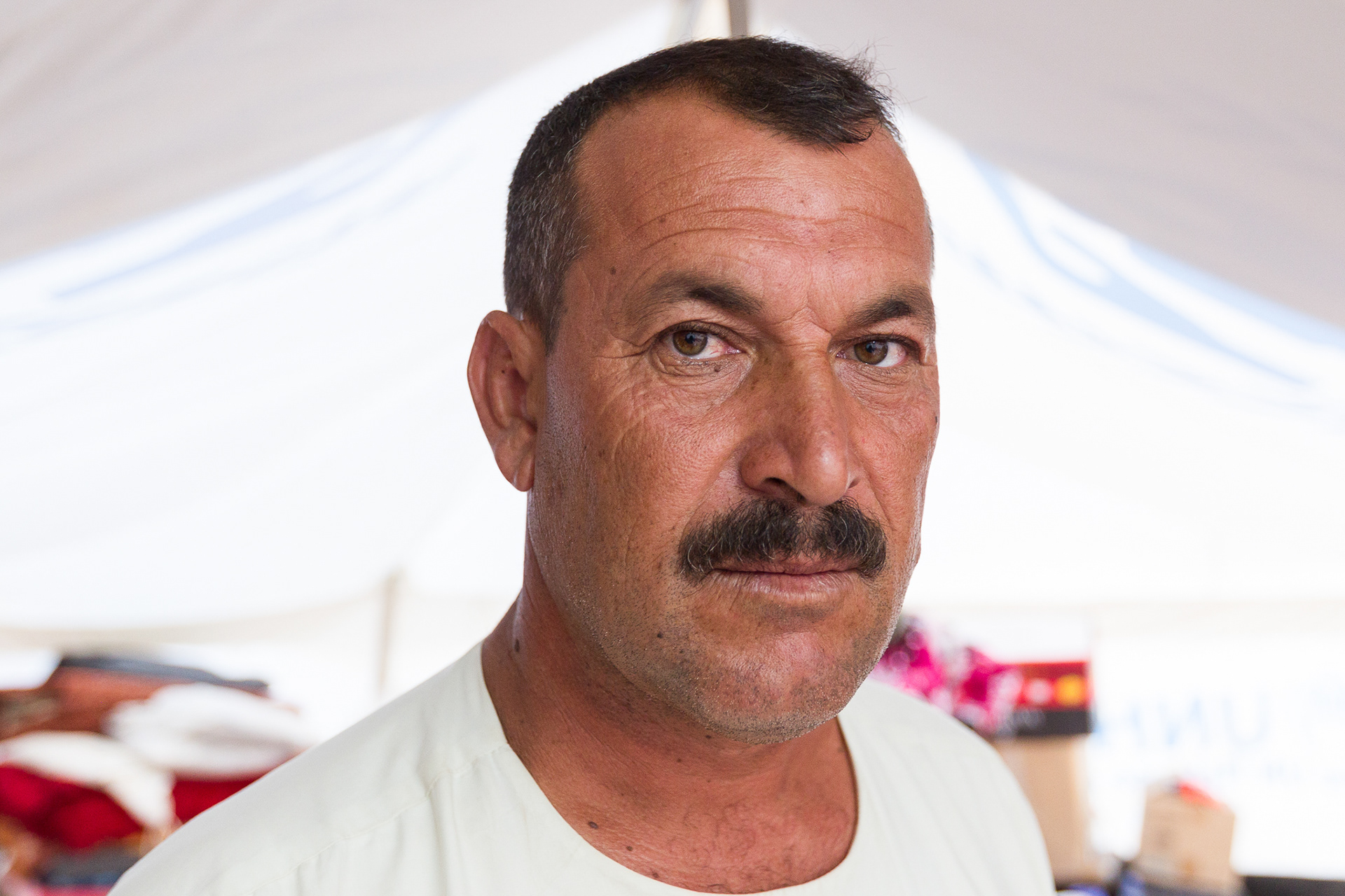 Ayad Hajjo, a Yazidi man displaced from his home on the Nineveh plain, has found refuge in a school playground, one of many camp locations in Khanke, Iraq. The town's population has swelled from 25,000 to 100,000 as ISIS forces drive religious minorities from Mosul and the area of the Ninevah plain.
