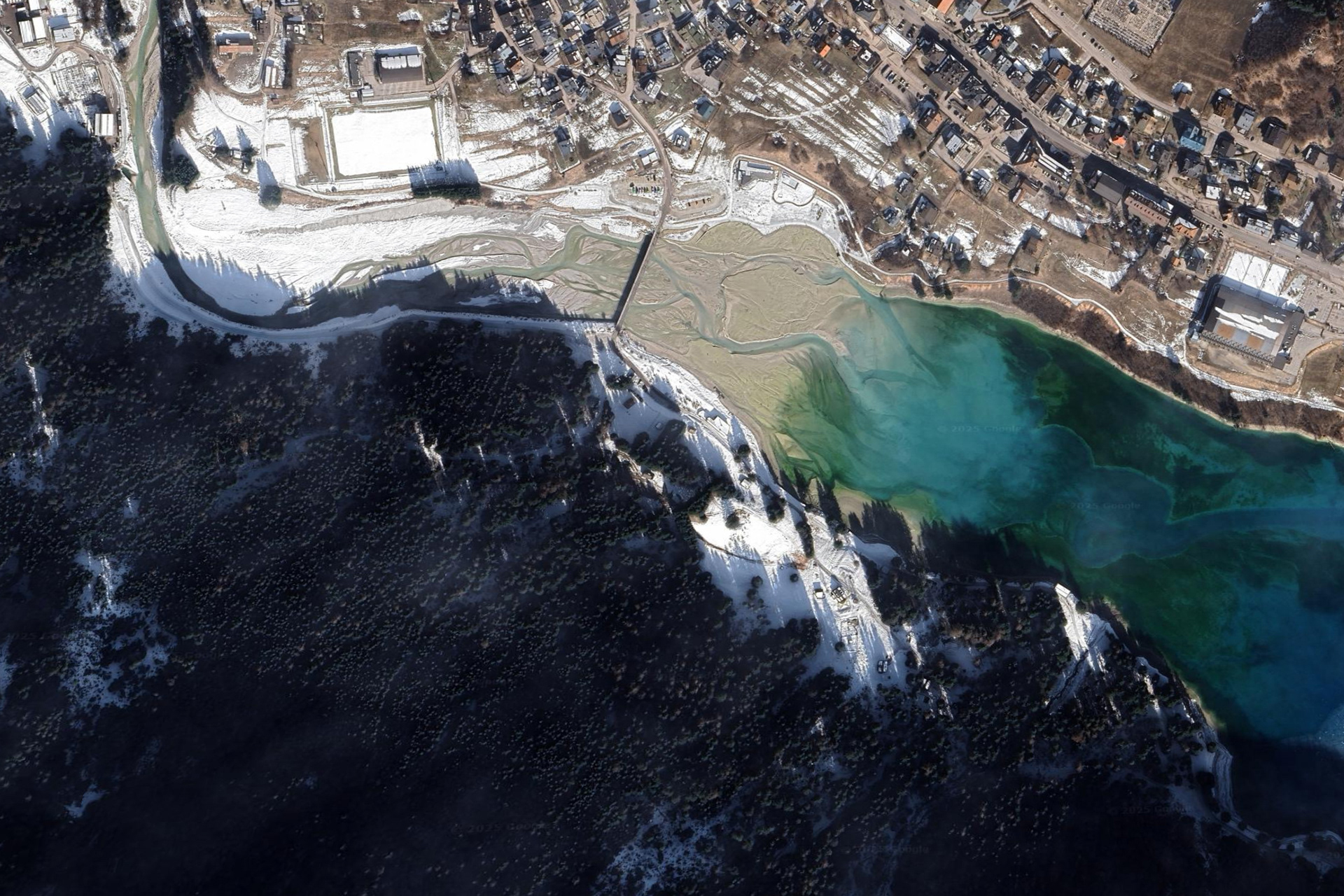 Immagine aerea da Google Earth, vista sul lago di Auronzo, nel quale si nota l'enorme mole di ghiaia e altri residui depositati che riempiono il bacino idrografico.