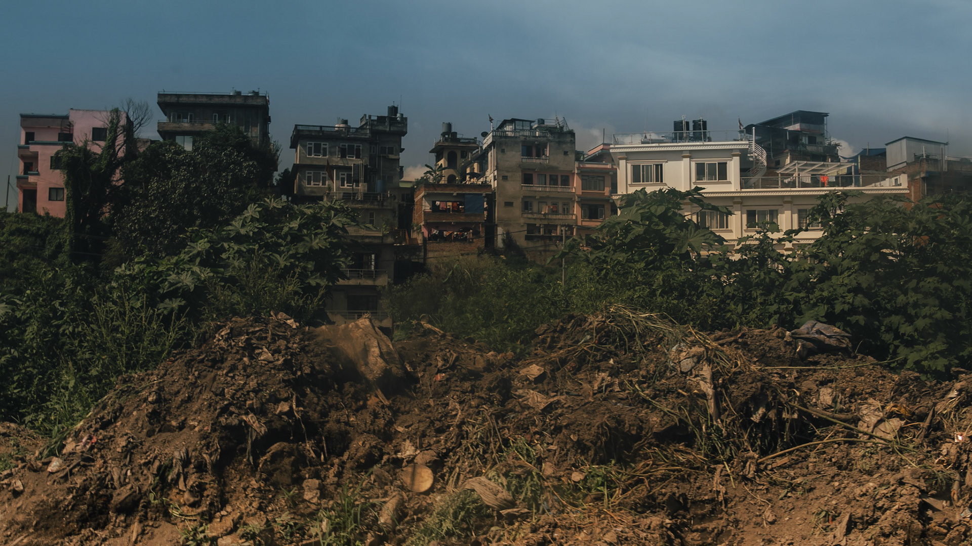 Piles of mud and grit left on roads, visible in Kathmandu to all.