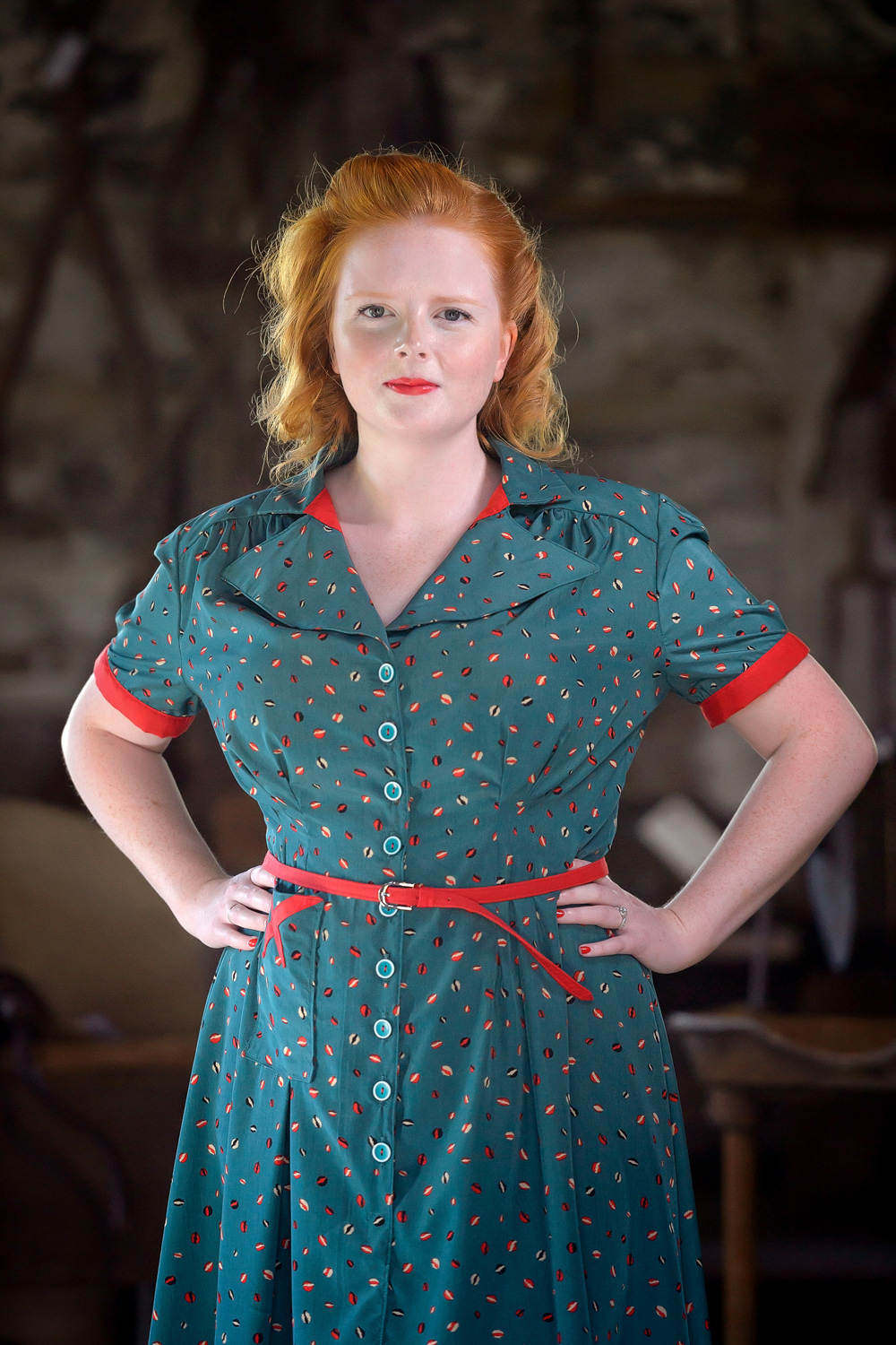 1940s Day Dress: This rayon dress inspired by the 1940s is gathered along the shoulders, front and back. with darts to create a fitted waist. The dress is made with matching red detailing and a custom belt.