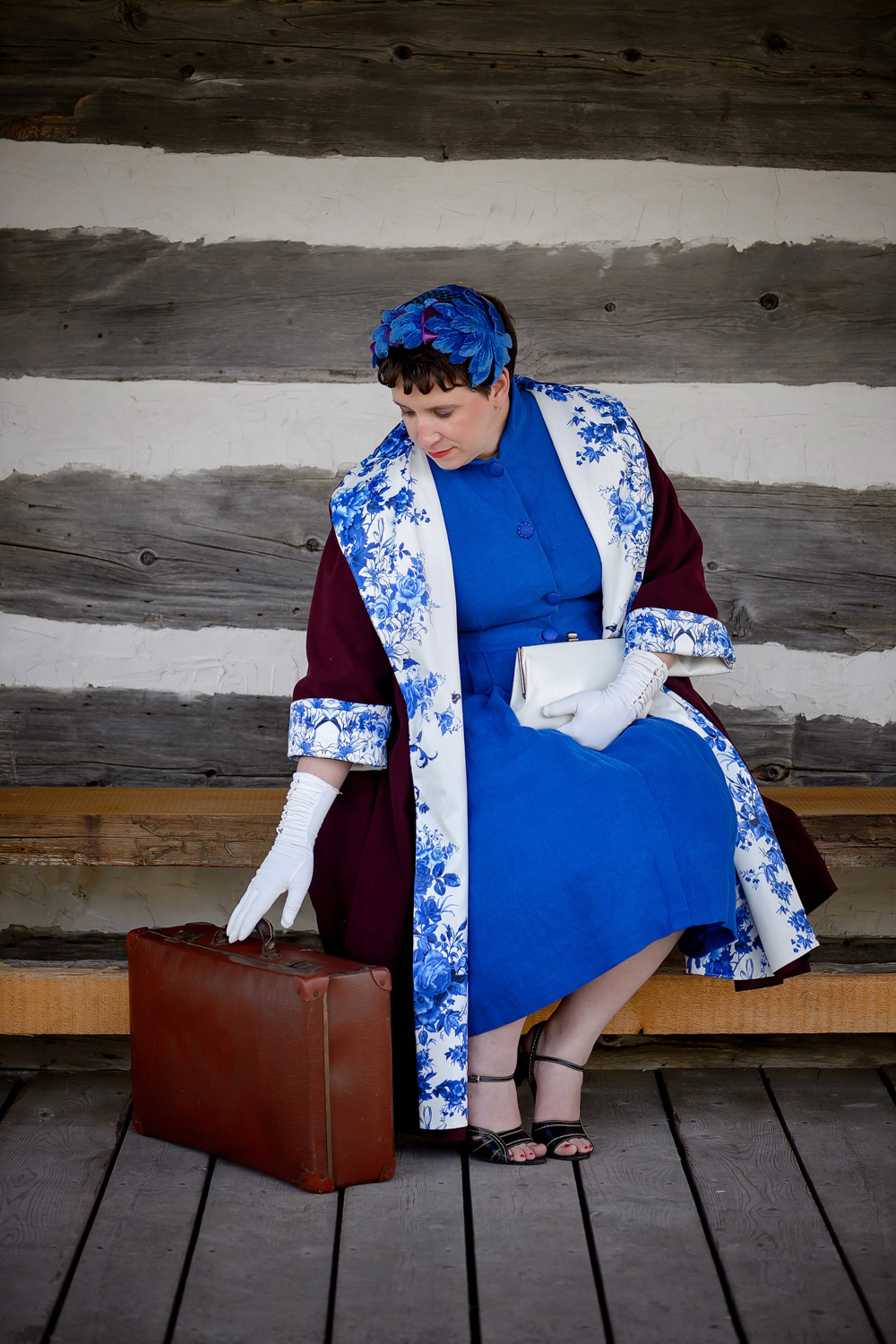 1950s Swing Coat and Dress: This purple wool swing coat is typical of the 1950s. It’s completed with a luxurious silk satin lining for a classic sophisticated look. A blue linen dress with a high neckline and pleated skirt pulls the whole outfit together.