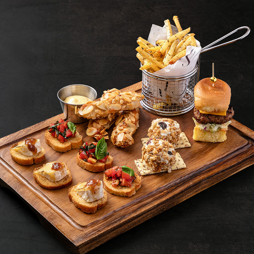 A photograph of a spead of various finger foods on a board. This image serves as an introductory image to gallery of food photographs of spreads and platters.