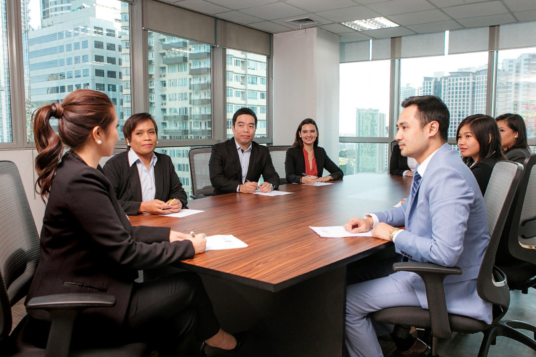 A corporate lifestyle image featuring a team meeting at an office board room.