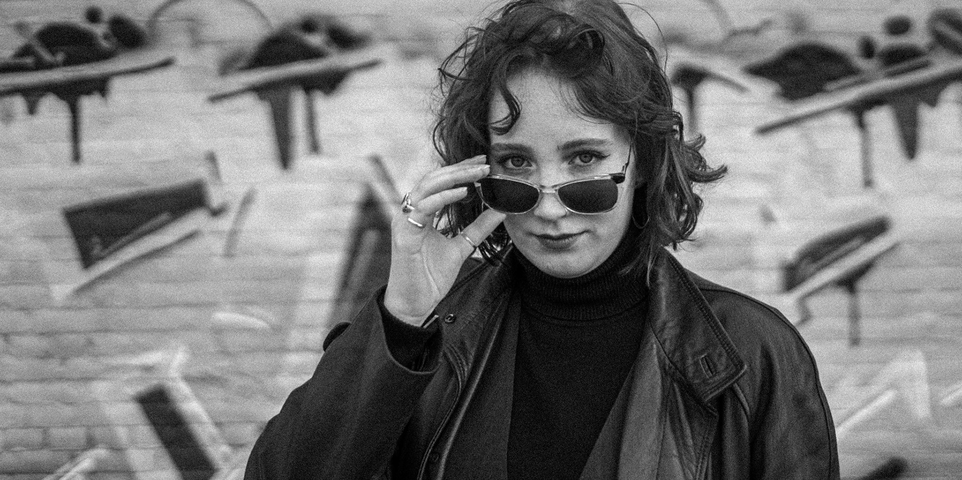 Portrait of Sophie in front of graffiti backdrop