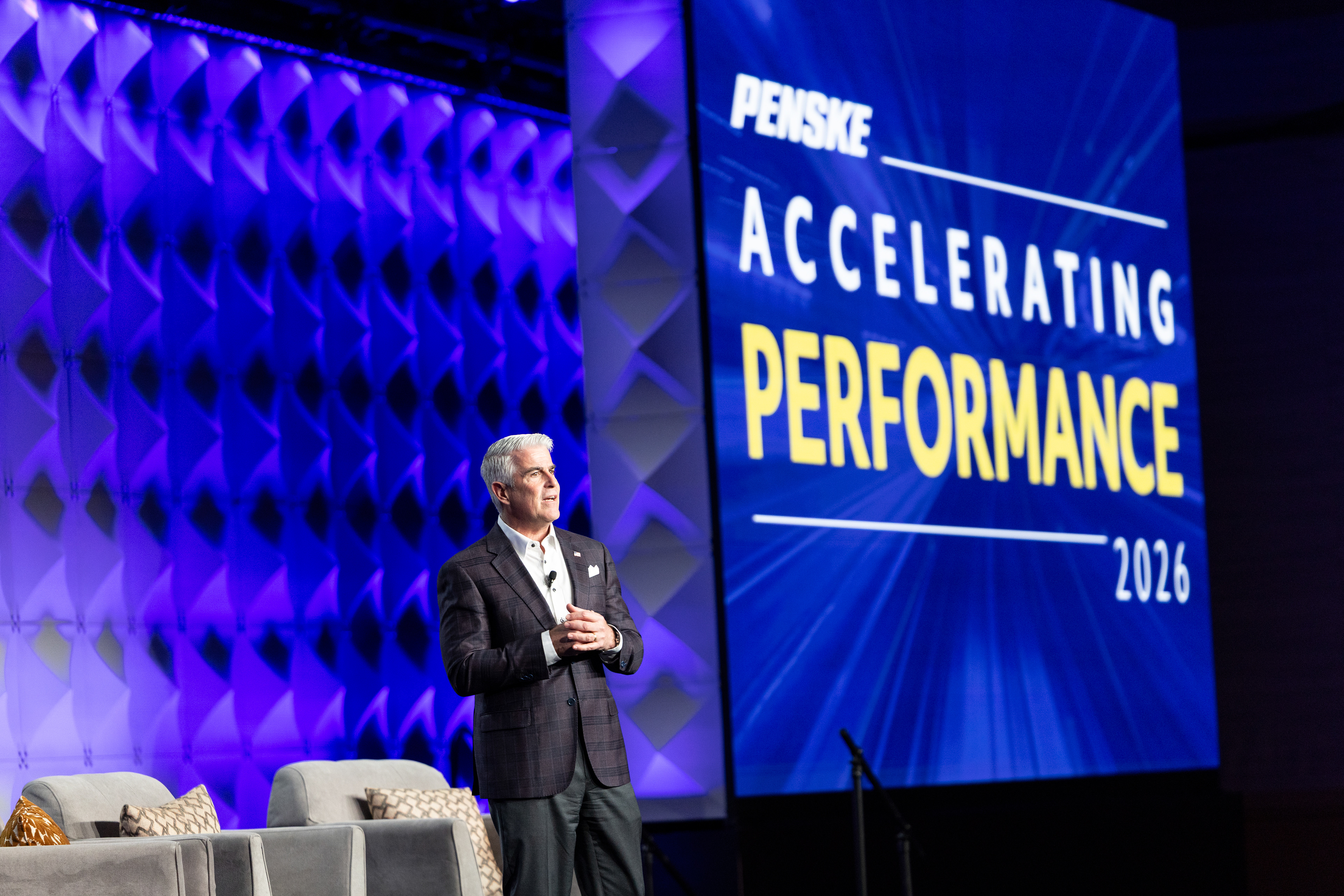 Speaker on stage in front of Accelerating Performance 2026 screen