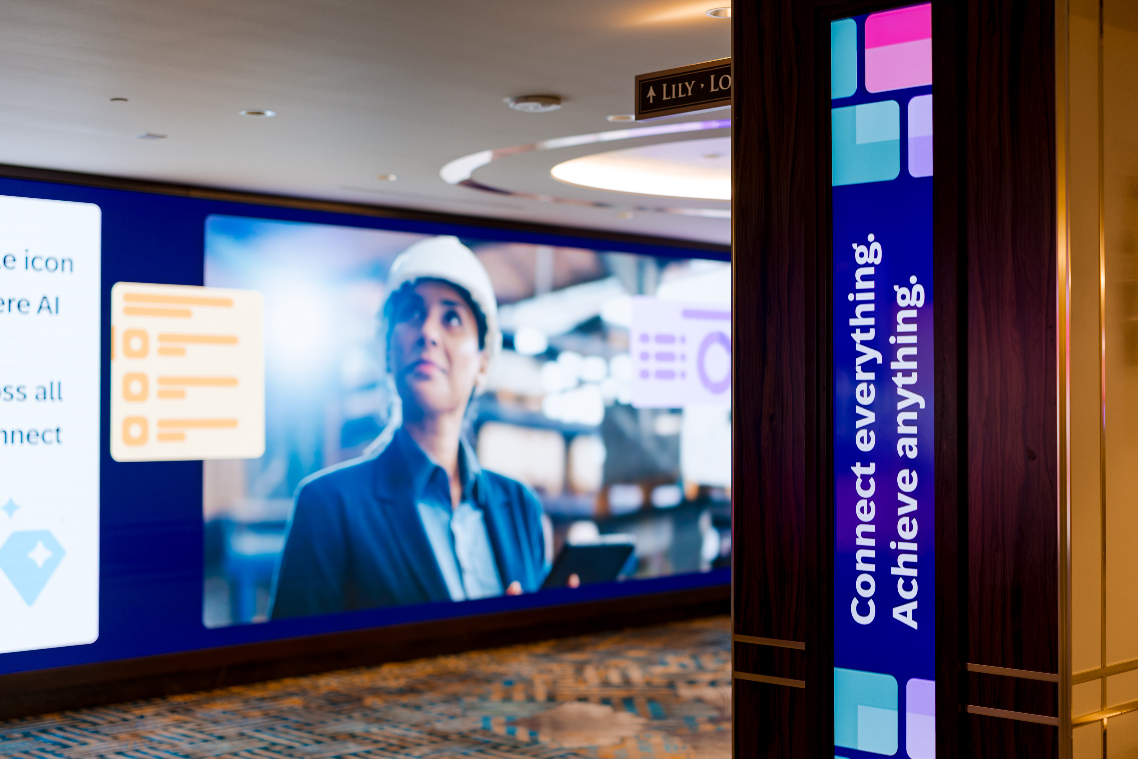 Digital wall display with AI-worker graphic and hallway signage