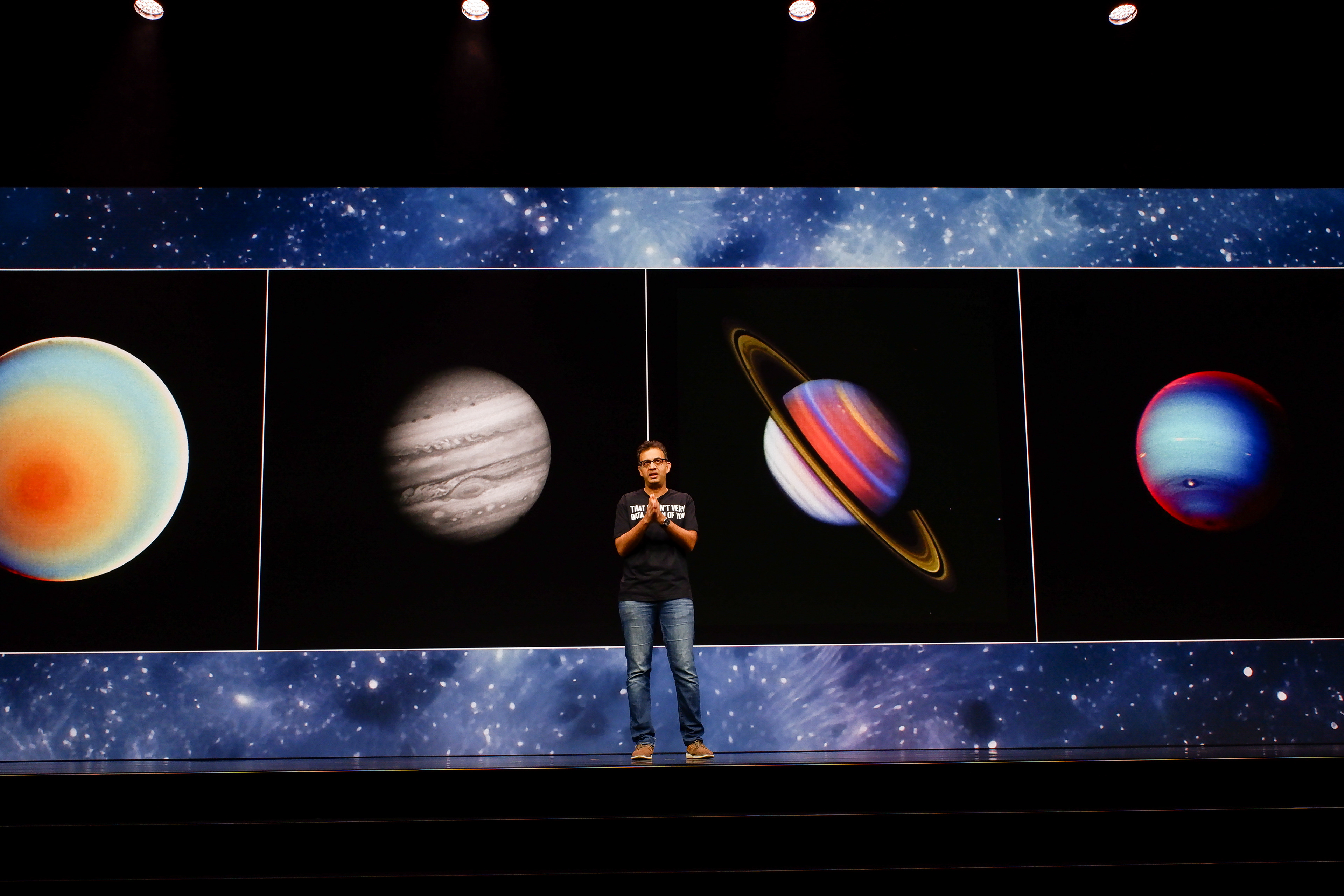 Speaker walking across stage in front of Business Network AI screen