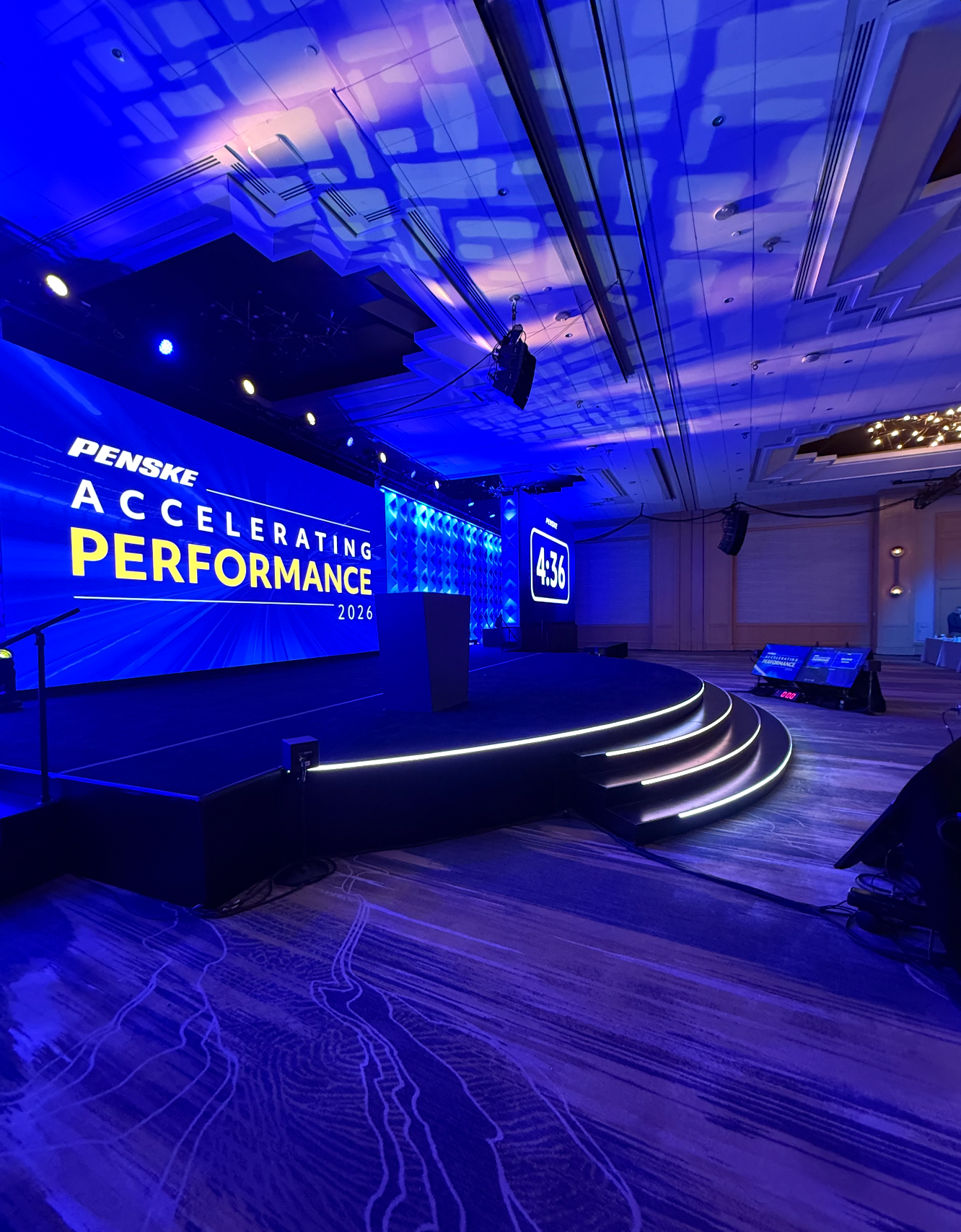 Wide ballroom stage shot with Accelerating Performance screen