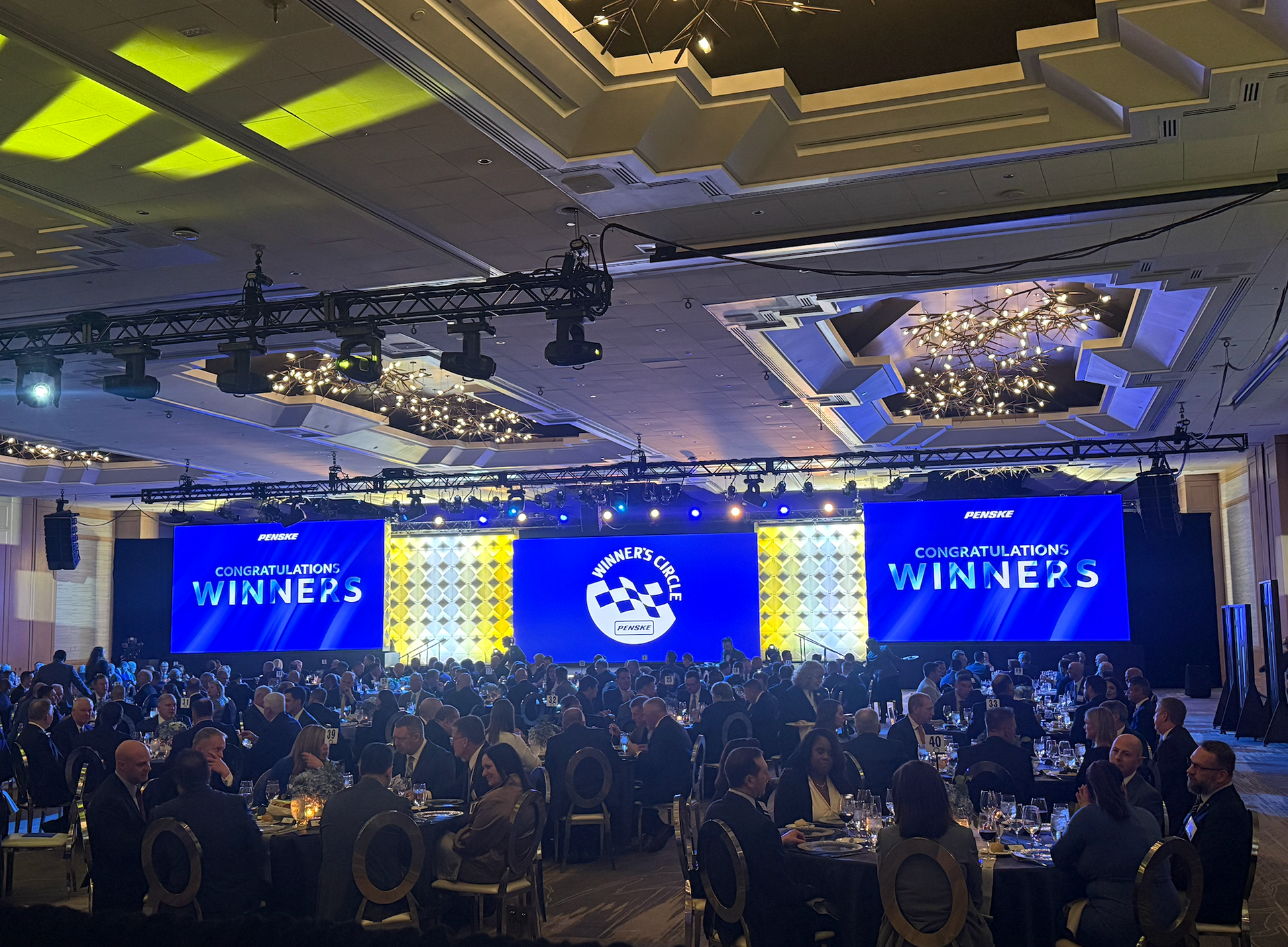 Wide shot of a banquet awards dinner room with Winner's branding