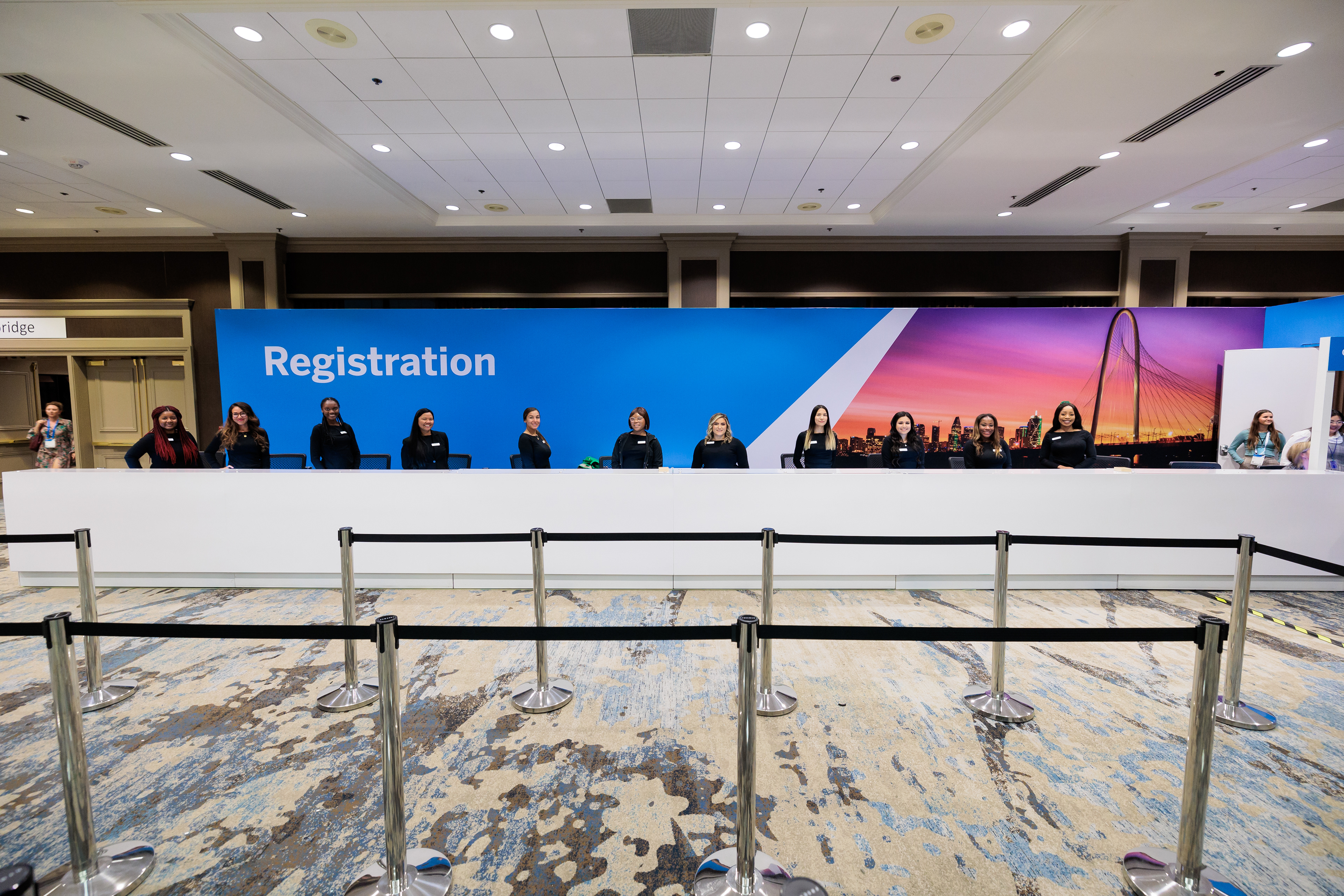 Sponsor-logo stage wall paired with a registration desk photo
