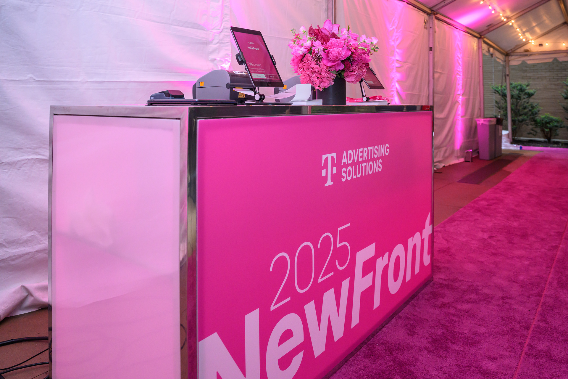NewFront registration desk with magenta counter signage
