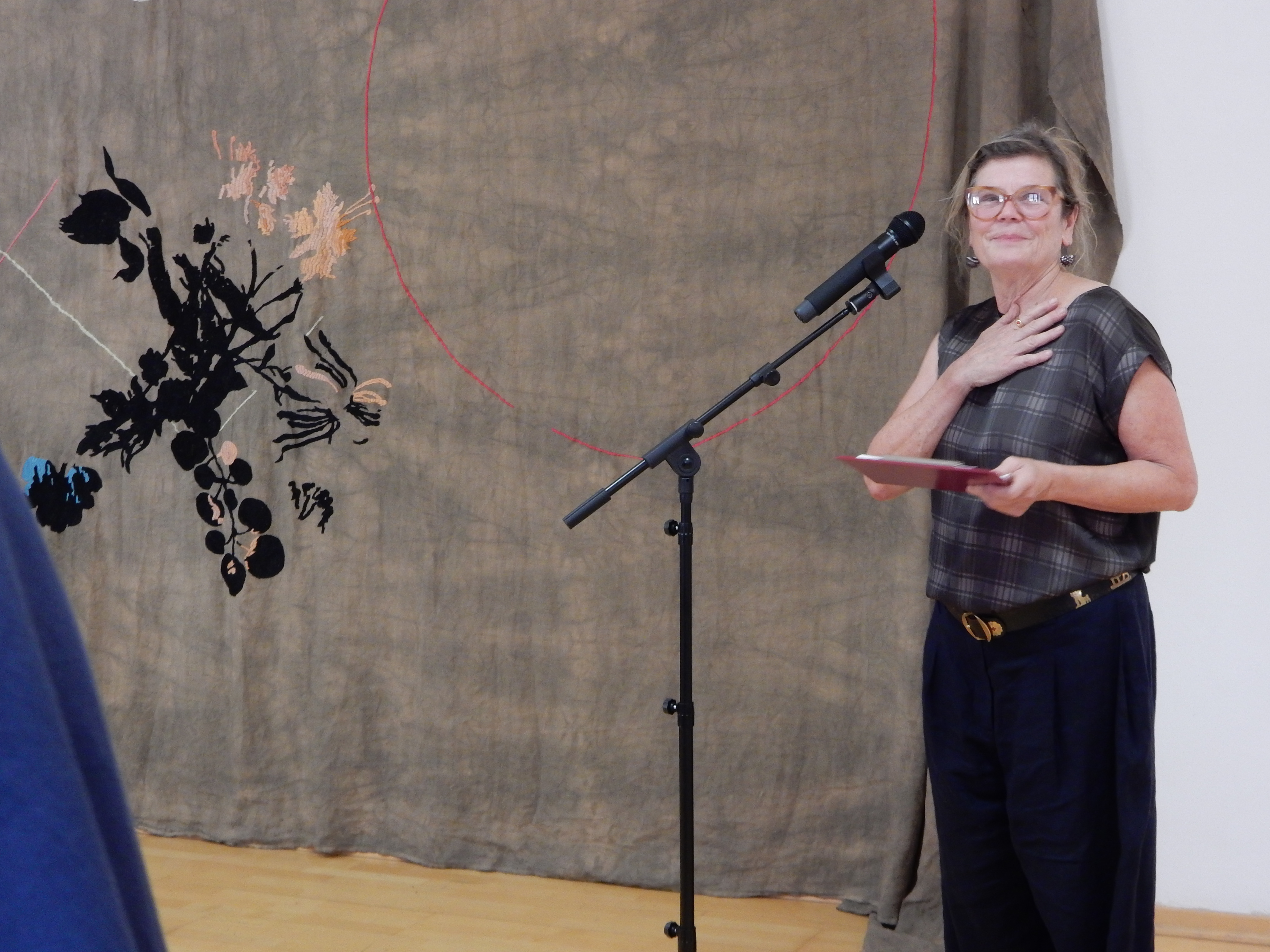 Frenzi Rigling eröffnet die Ausstellung, im Hintergrund die Arbeit von Frederike Schweizer 