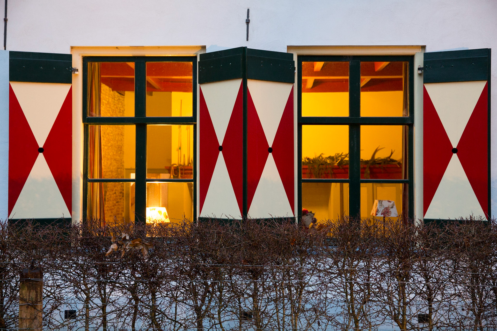 Traditionele raamluiken met rood wit zandloperfiguur; Traditional shutters