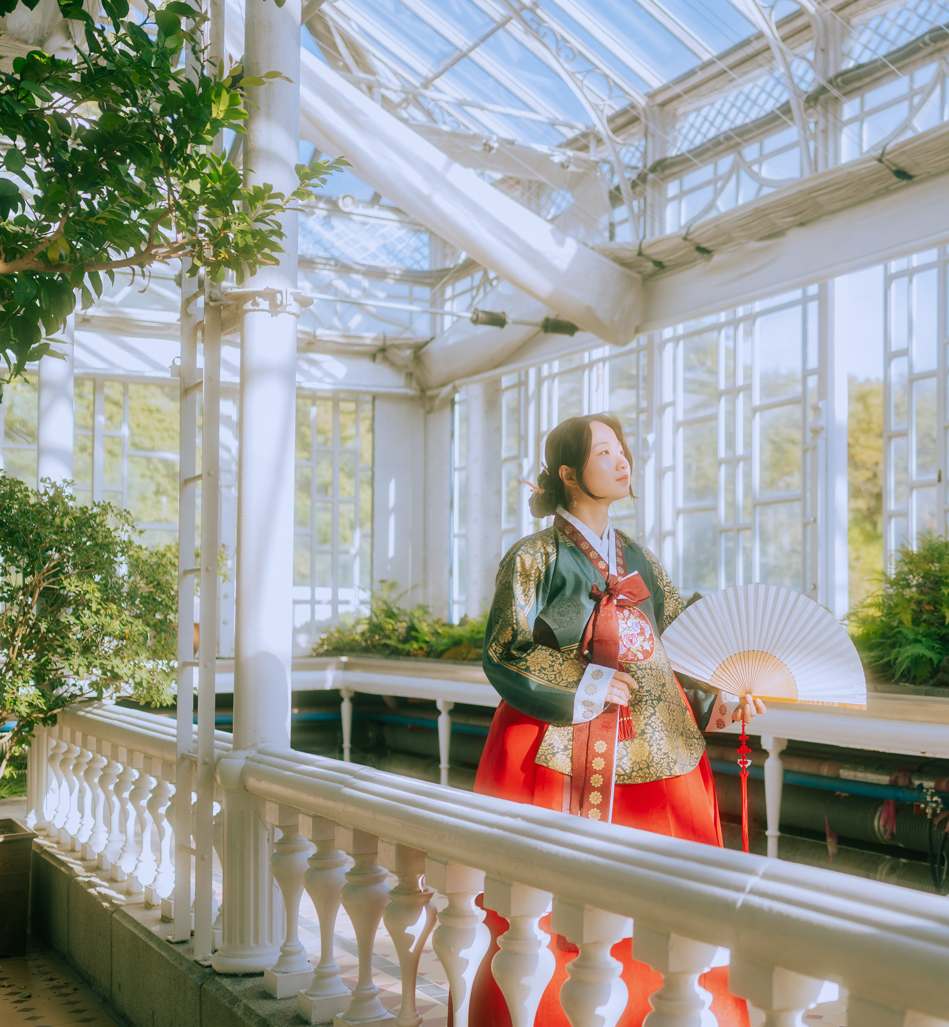 Celebrate Korean culture with a traditional Hanbok photoshoot in Seoul. A graceful folding fan, intricate embroidery, and beautiful architectural details create an elegant portrait inspired by Korea's timeless heritage.