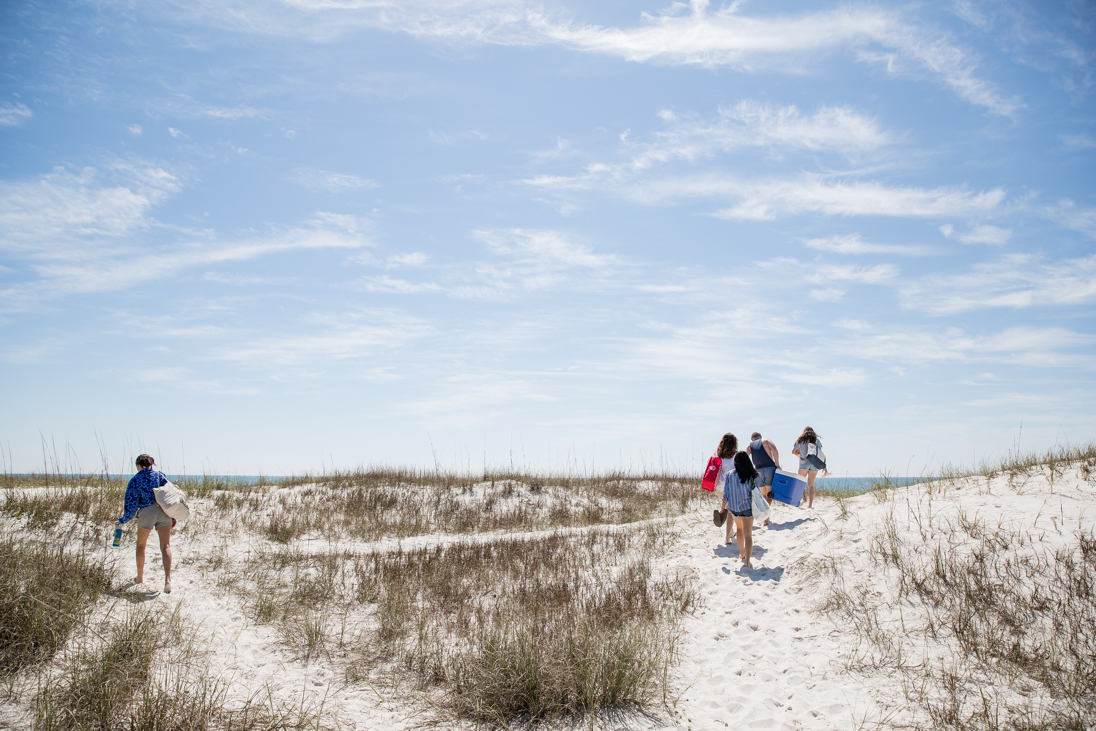 March 17, 2022, Pensacola, FL: College kids walk along the dunes while on Spring Break at Pensacola Beach, in Pensacola, Florida Thursday, March 17, 2022. (Photo by Aiden Shertzer)
