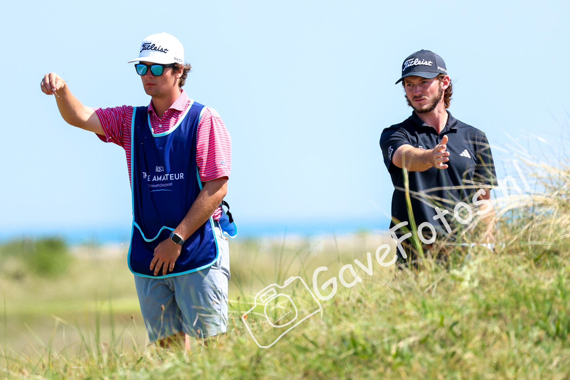 Tom Osborne bekijkt de windrichting samen met zijn caddy op hole 5 van Royal St George
