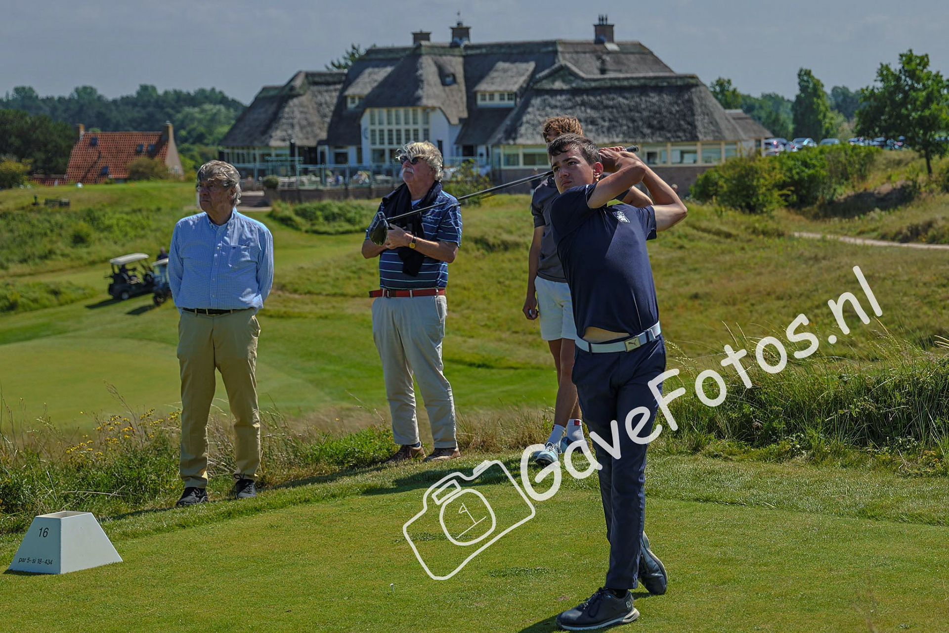 Jesse van Doorn slaat af onder het toezicht van een aantal leden van de Kennemer Golf &amp; Country Club