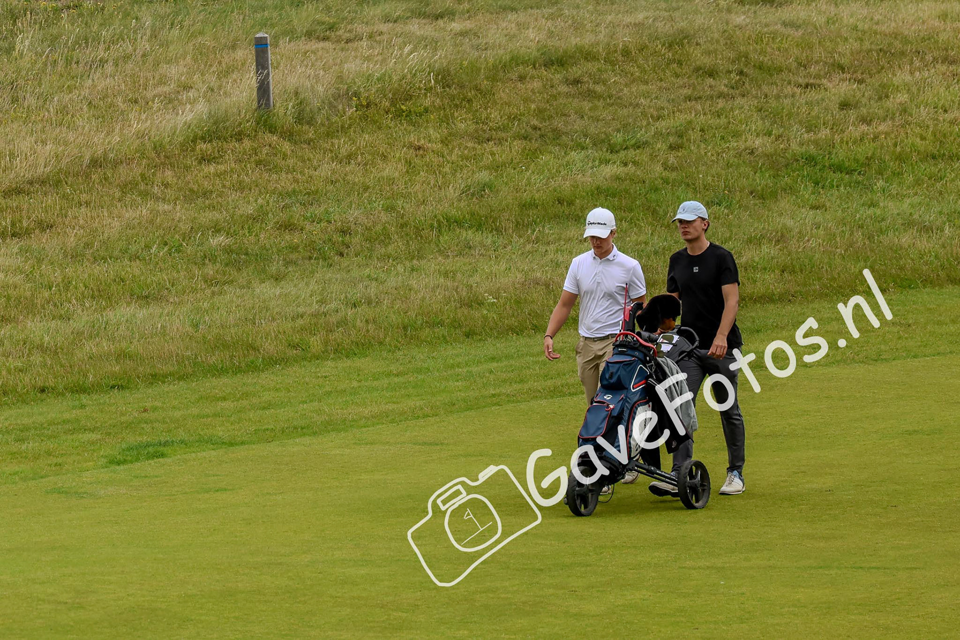 Thom Schoonveld met zijn caddy op de fairway van 18, tijdens de Kennemer Open 2025