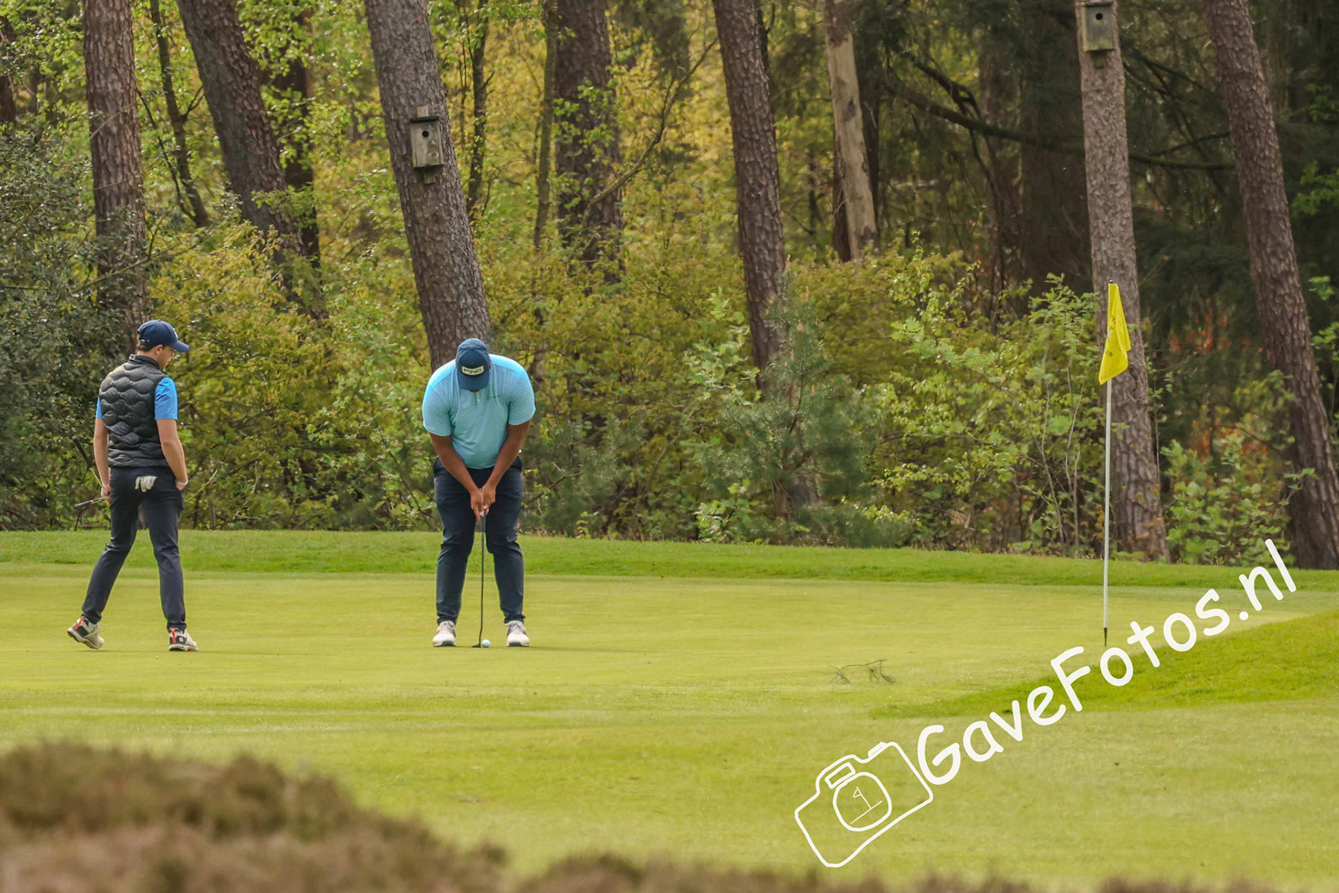 Ingmar Schenau (Noordwijkse) kijkt toe hoe zijn foursome partner Aydan Verdonk put op hole 5 van de Hilversumsche
