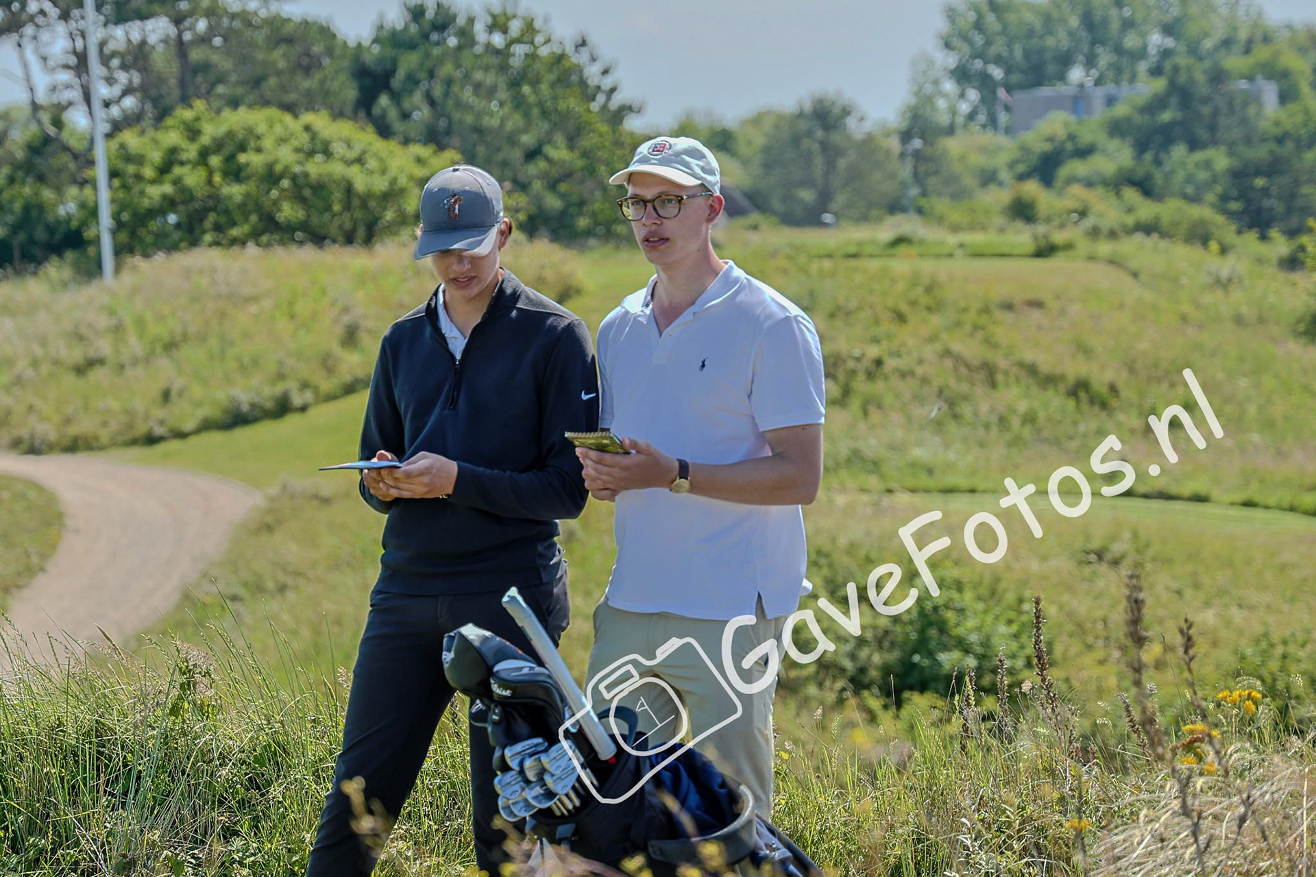 Speler en caddy in overleg op de te volgen strategie