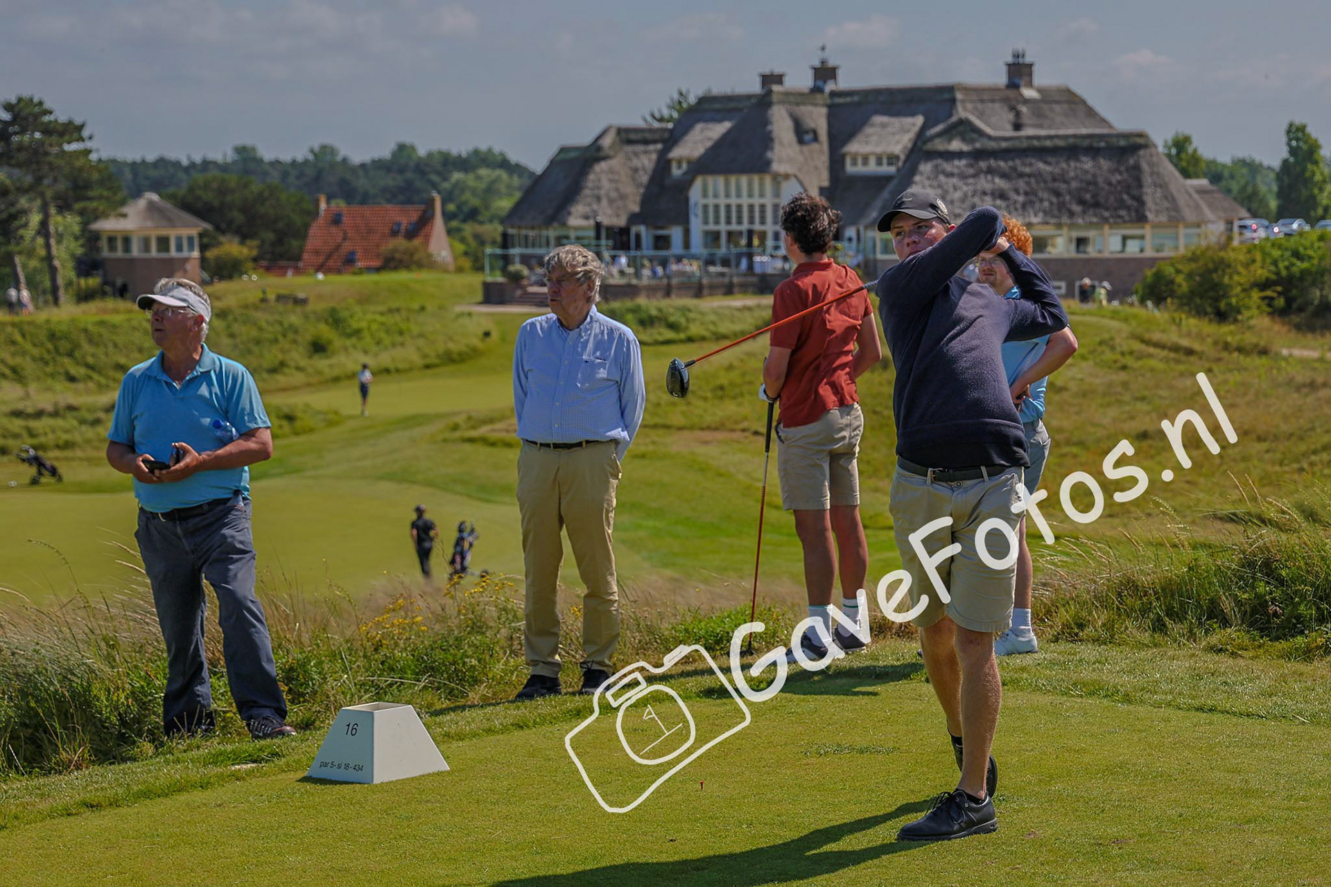Sil Thoonen slaat af onder het toezicht van een lid van de Kennemer Golf en Country Club