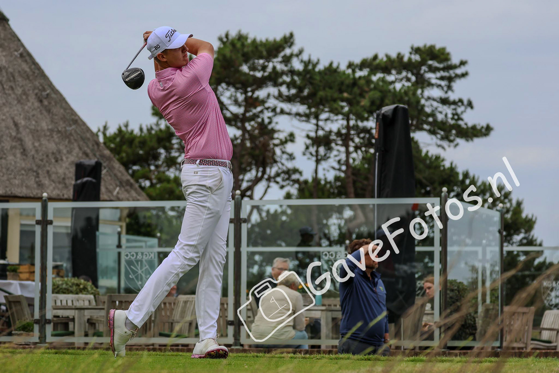 Bjorn Driessen slaat op op hole 10, naast het clubhuis van de Kennemer Golf en Country Club