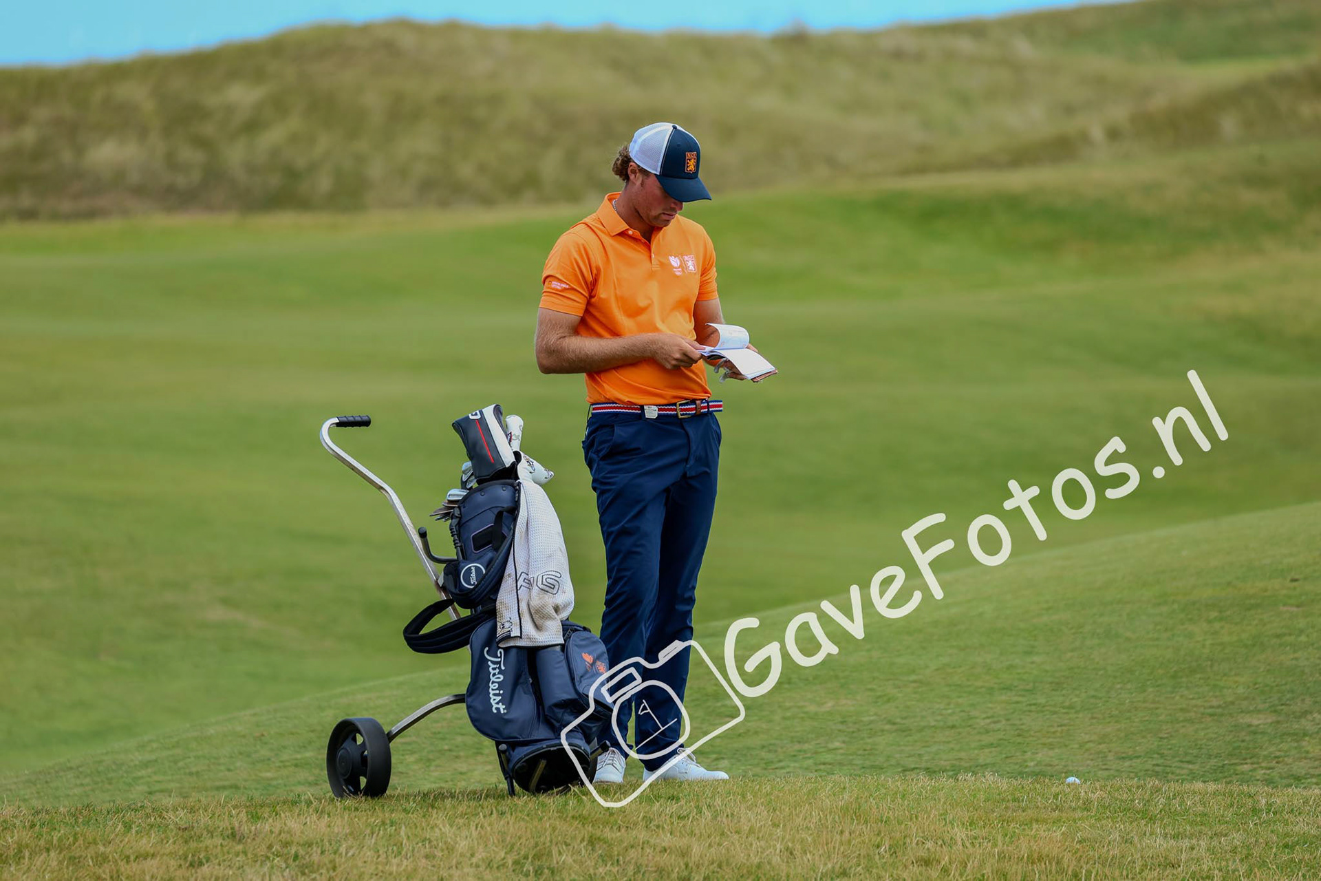 Benjamin Reuter bekijkt zijn aantekeningen op de fairway van hole 17 van Royal St George