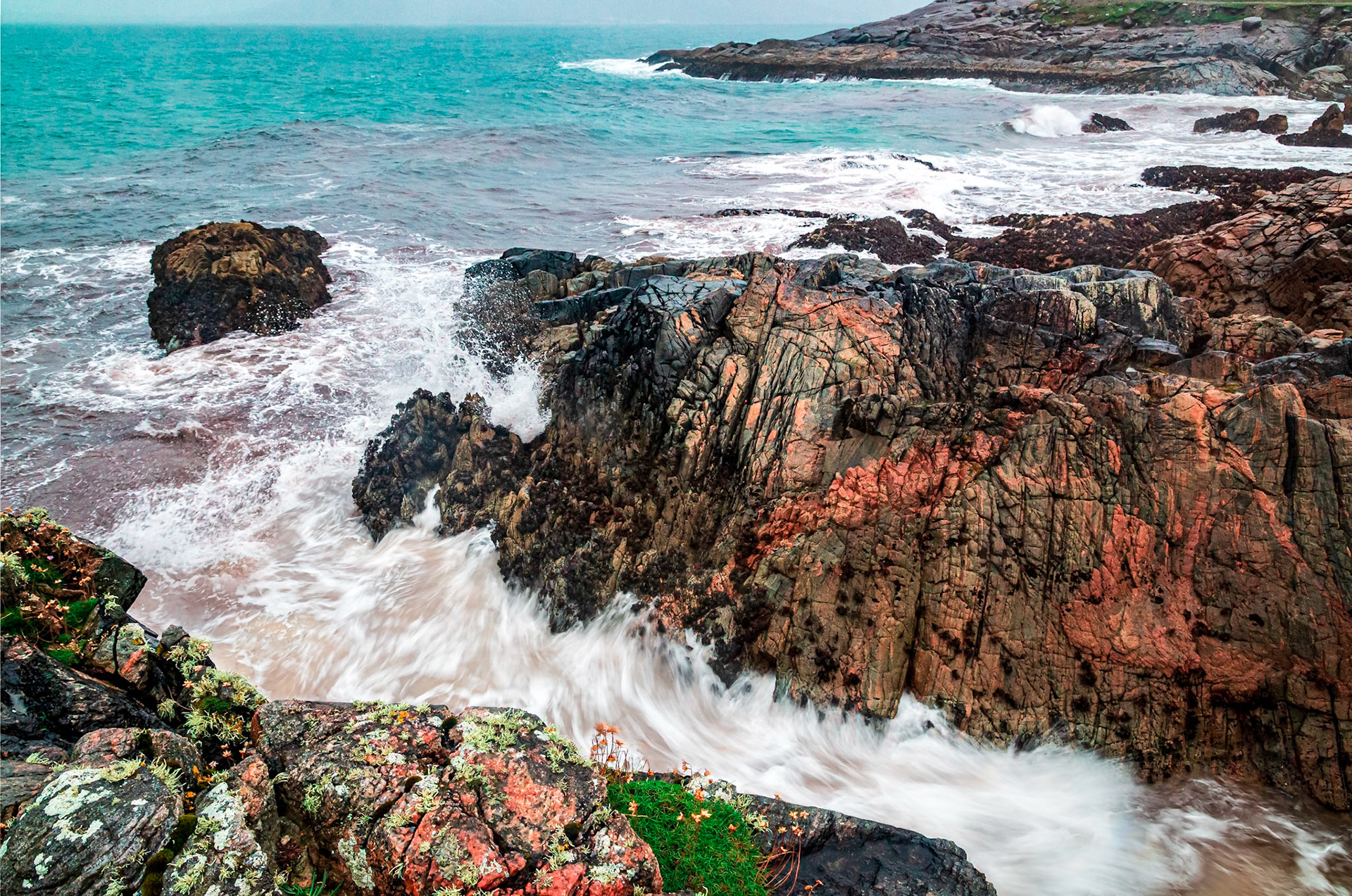 On the west coast of the Isle of Harris heavy wind brings the waves hard against the cliffs.