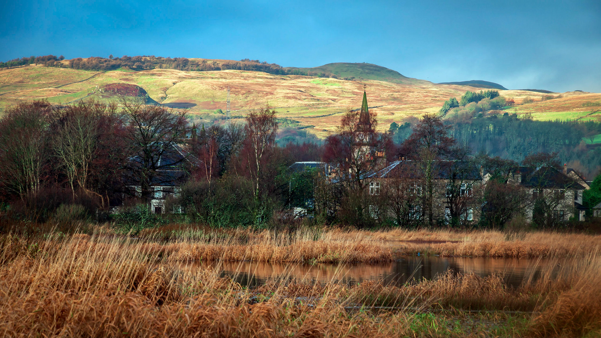 Ar the south west corner of Castle Semple Loch looking across to the village of Lochwinnoch as the sunrise breaks out from behind clouds.