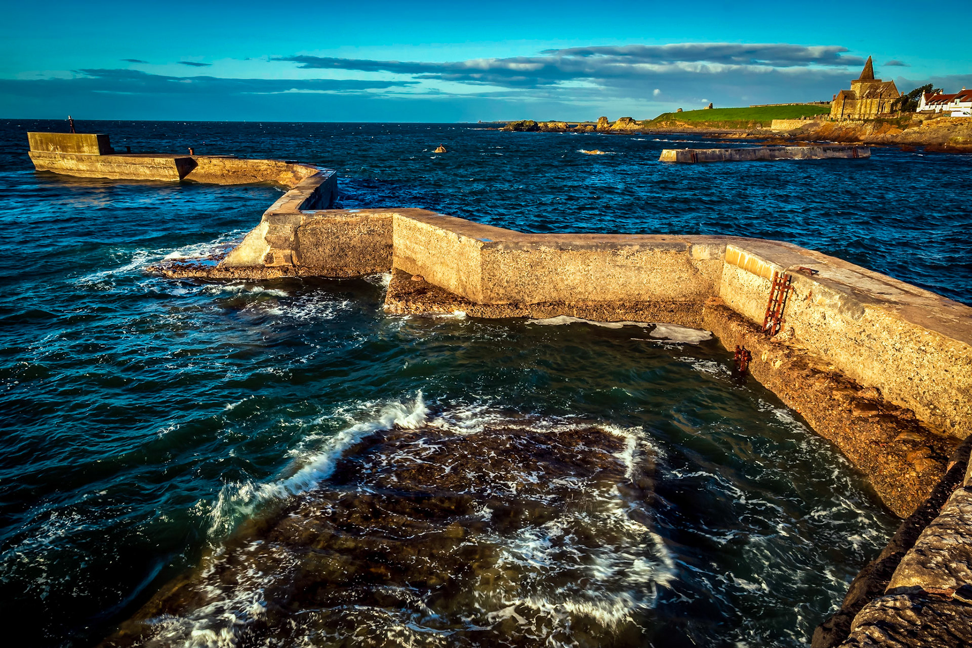 Morning light warms the cold concrete harbor defenses.