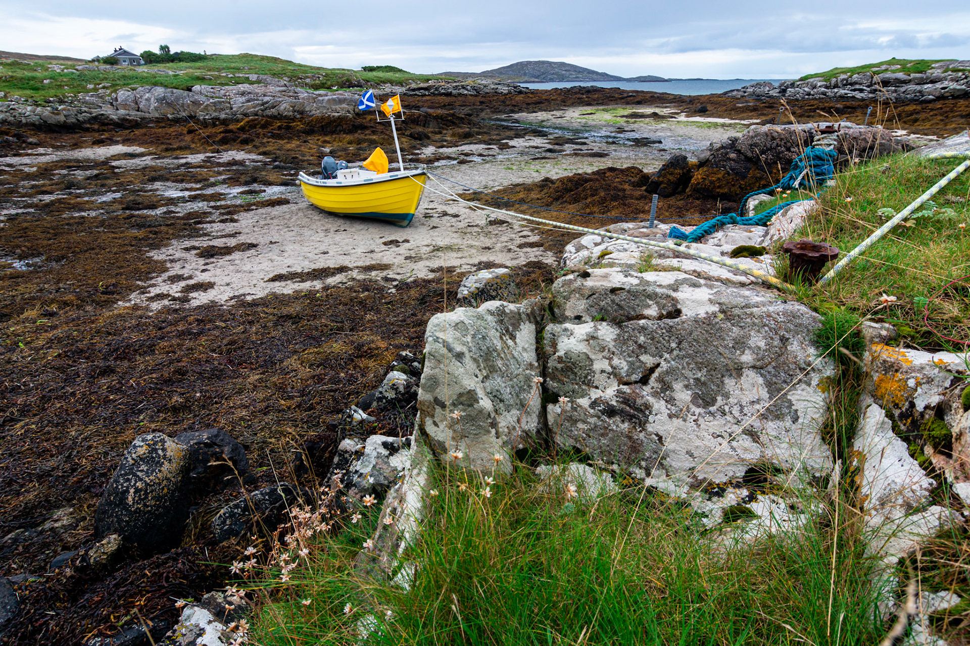 A colourful fishing boat is tide up waiting for the return of the tide.