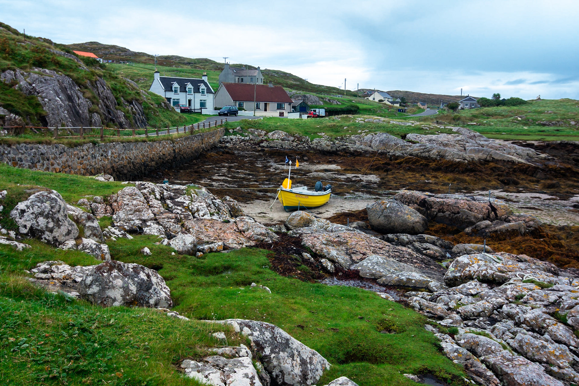 A colourful fishing boat is tide up waiting for the return of the tide.