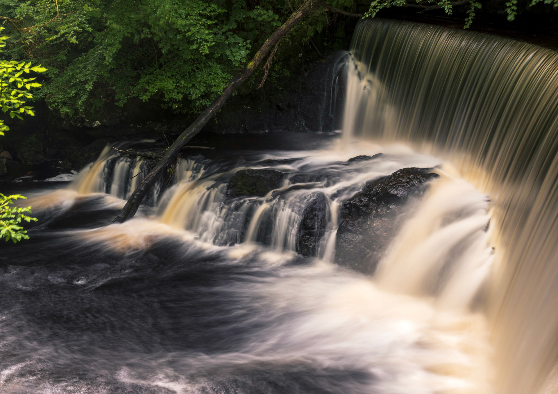 A sudden shaft of light highlights part of the weir.