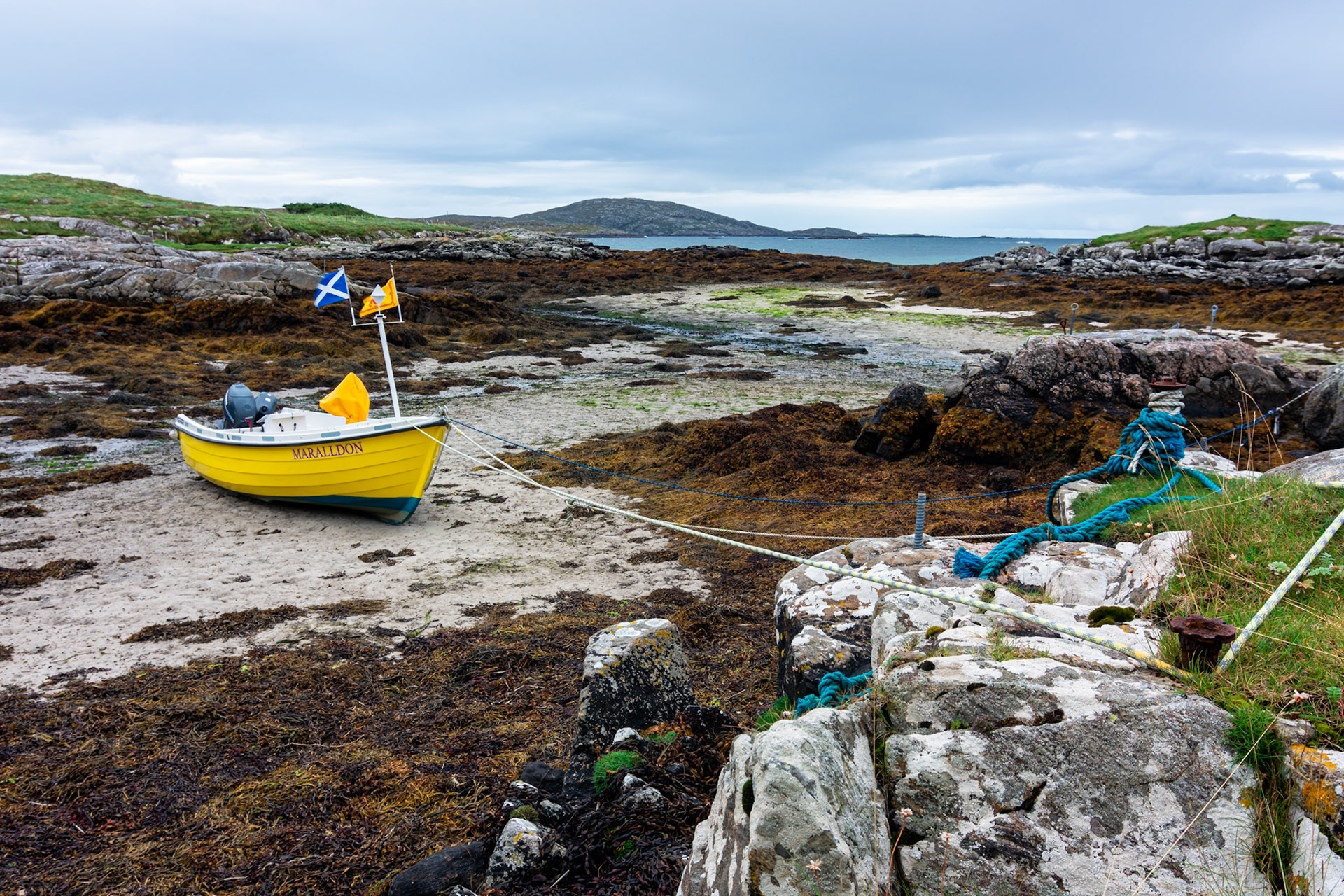 A colourful fishing boat is tide up waiting for the return of the tide.