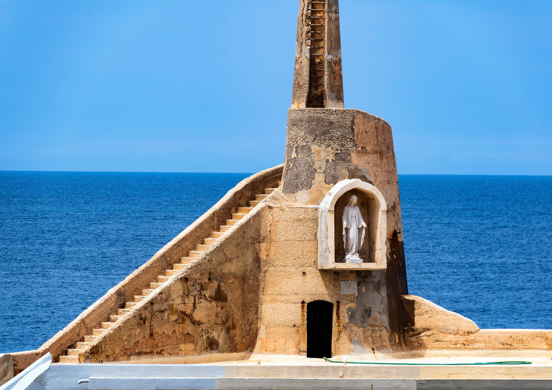 A statue of the Virgin Mary at one corner of Malta's Cirkewwa harbour were the Gozo ferry arrives.