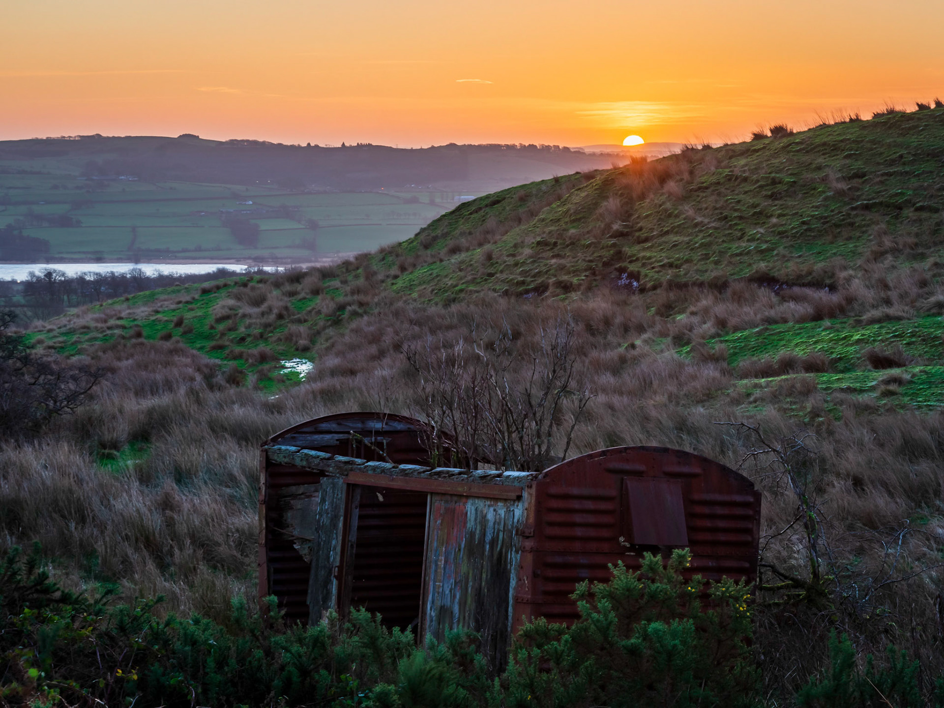 The sunrise over an old railway wagon, which propably came from a now disussed nearby railway line.