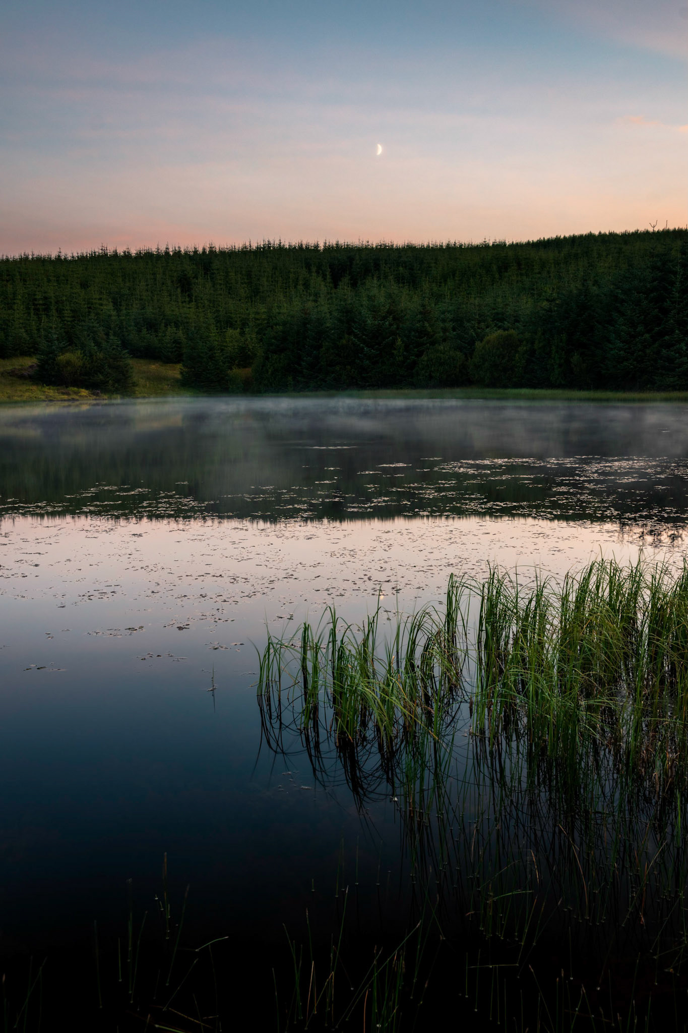 As night falls the last light of the day strikes Ladymuir Reservoir.