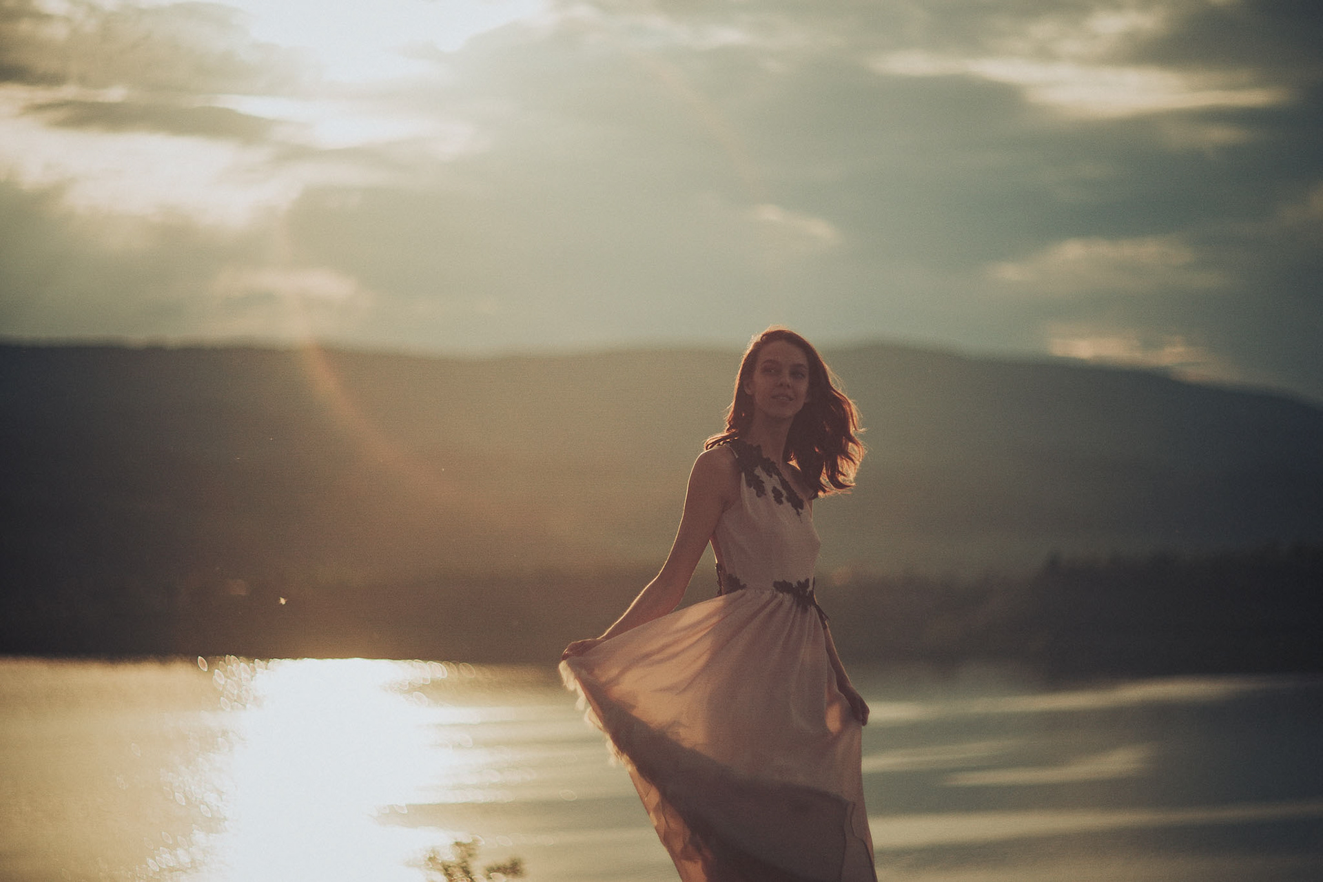 Момиче развява своята рокля на залезна светлина