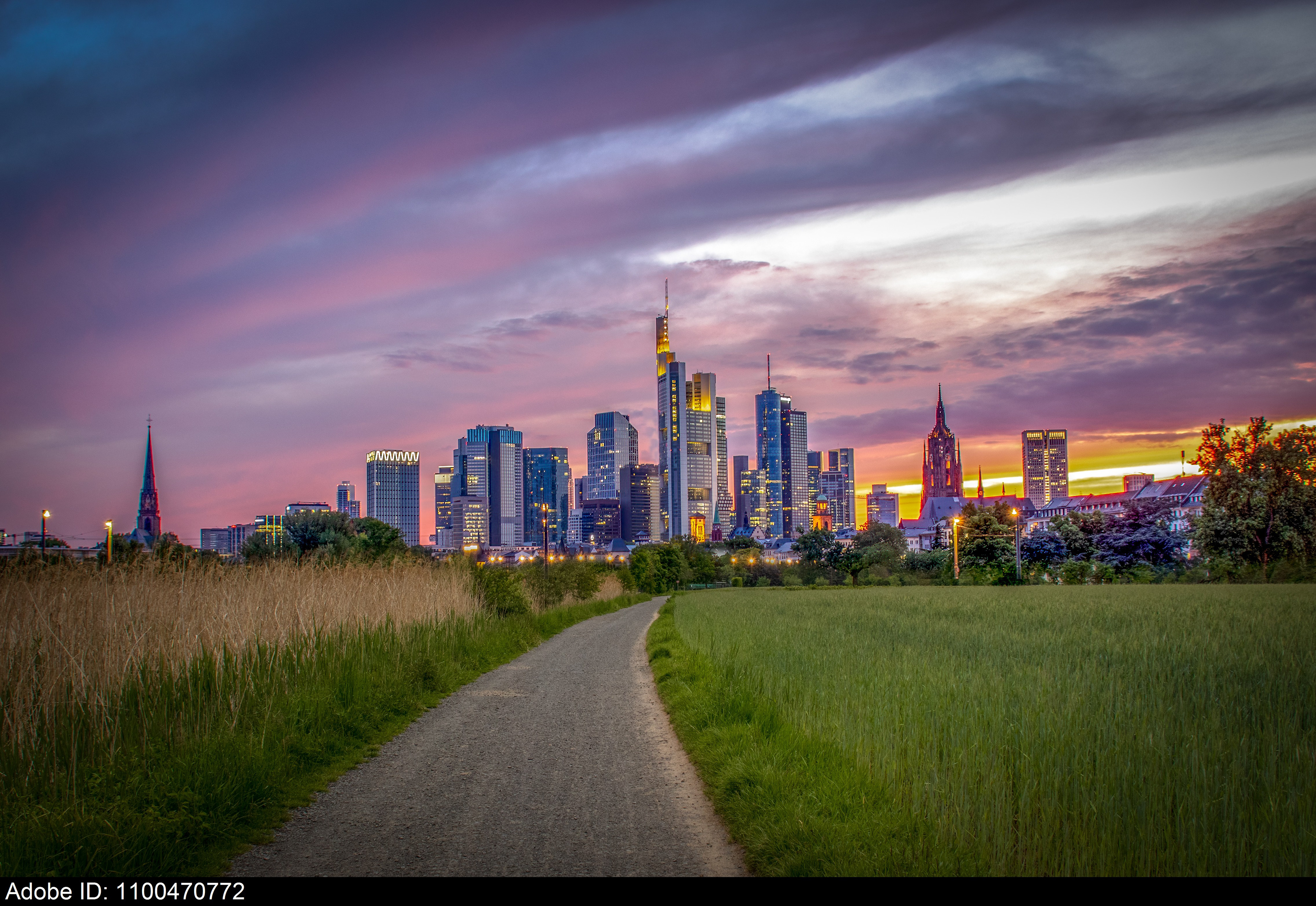 1100470772  Sunset Skyline of Frankfurt with Pathway and Fields in Foreground